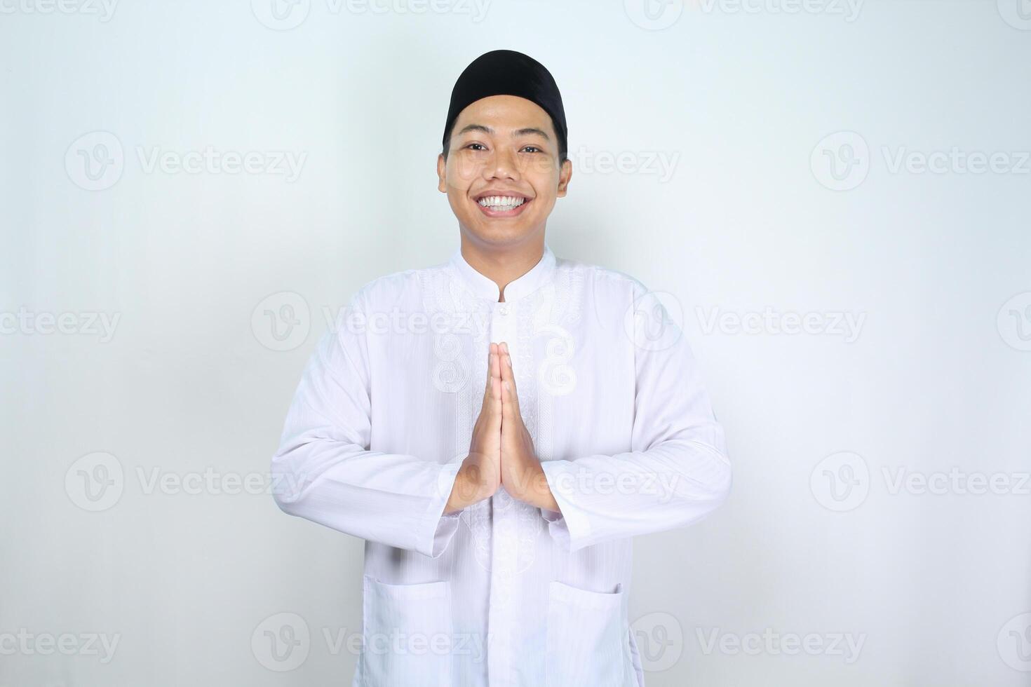 asiatico musulmano uomo sorridente per dare saluto nel eid mubarak celebrazione e accogliente Ramadhan isolato su bianca sfondo foto