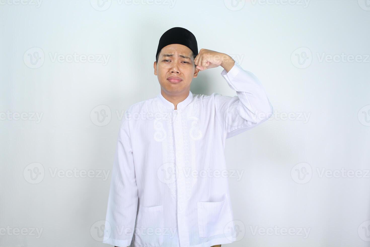 triste asiatico musulmano uomo pianto con asciugandosi lacrime isolato su bianca sfondo foto