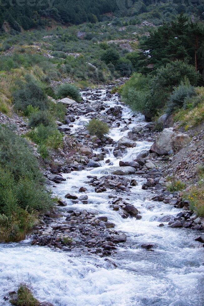 montagna fiume contro il sfondo di sparpagliato grande pietre e massi. foto