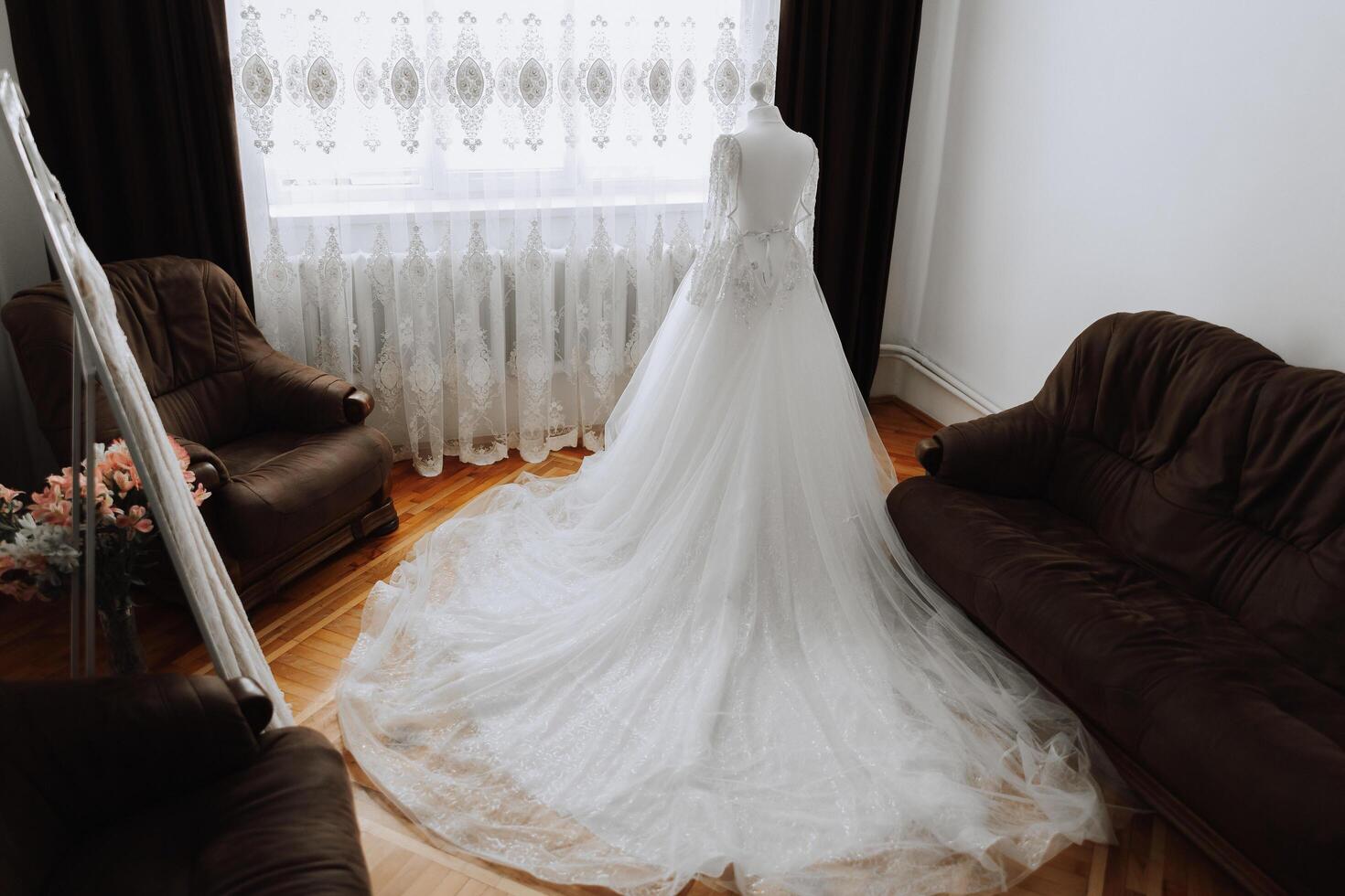 Camera da letto interno con nozze vestito preparato per il cerimonia. un' bellissimo lussureggiante nozze vestito su un' indossatrice nel un' Hotel camera. foto