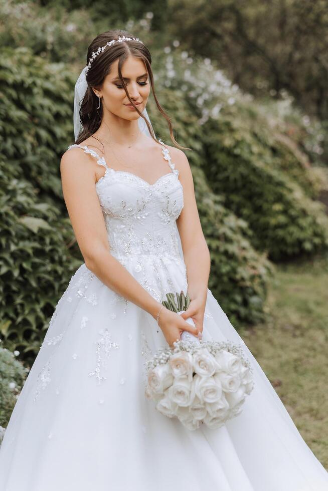 bellissimo sposa con nozze fiori mazzo, attraente donna nel nozze vestire. contento sposini donna. sposa con nozze trucco e acconciatura. sorridente sposa. nozze giorno. bellissima sposa. matrimonio. foto