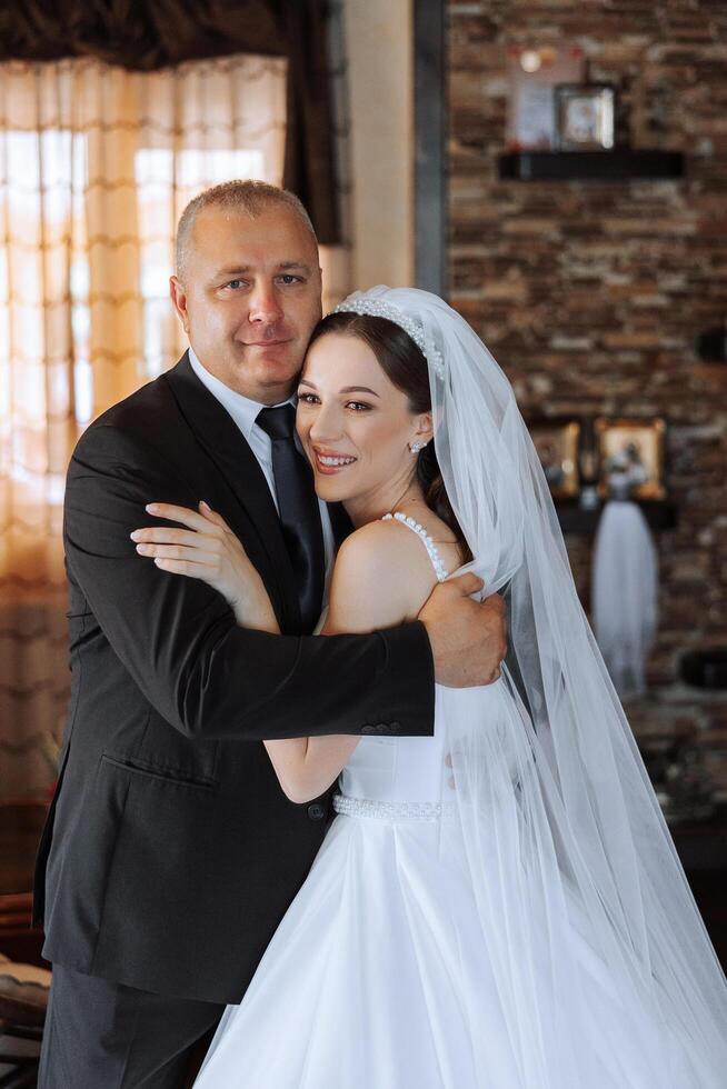 un' bellissimo sposa con sua padre su sua nozze giorno. il migliore momenti di il nozze giorno. figlia e padre. foto