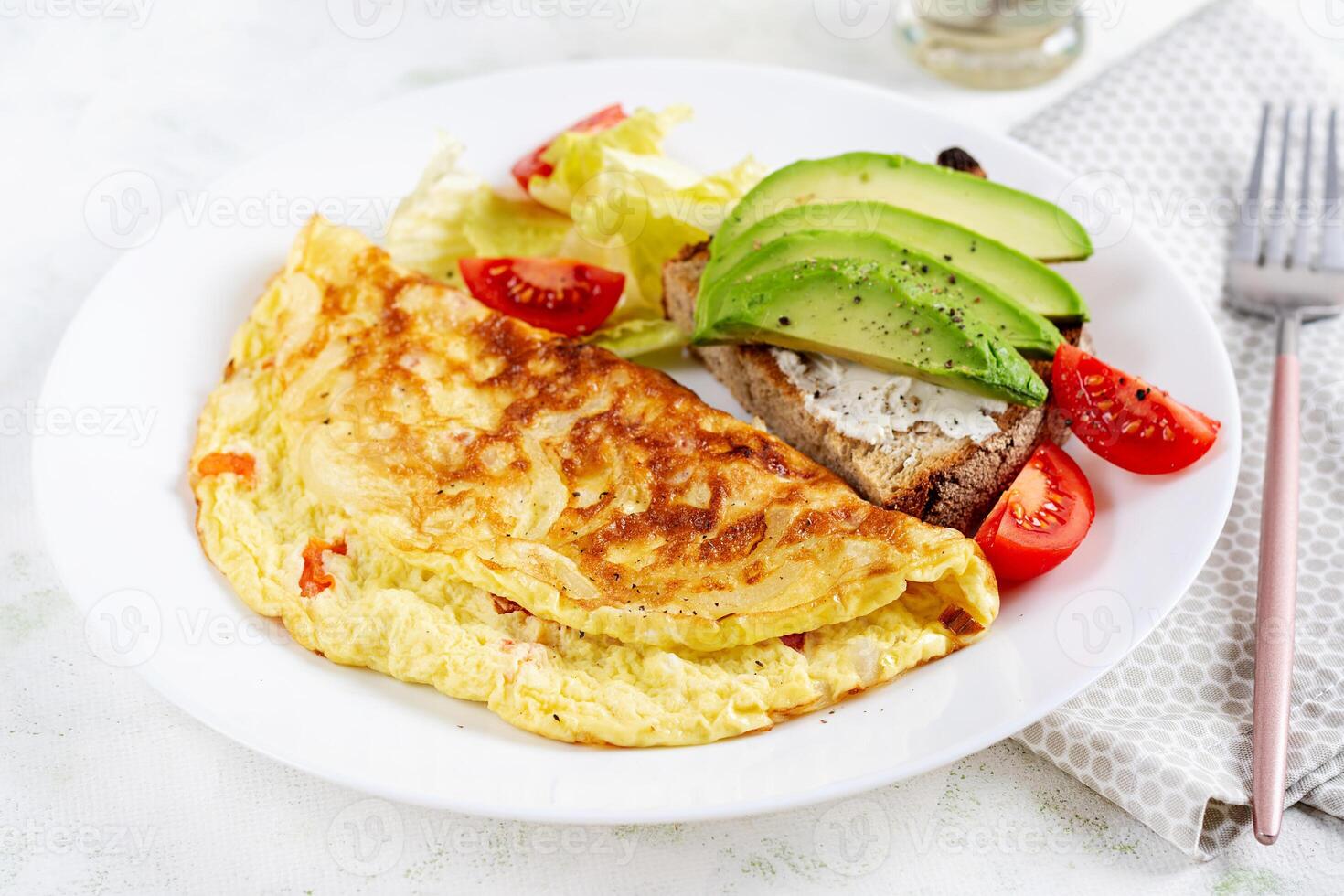 frittata con pomodori e crostini con avocado su bianca piatto. frittata - italiano frittata. foto