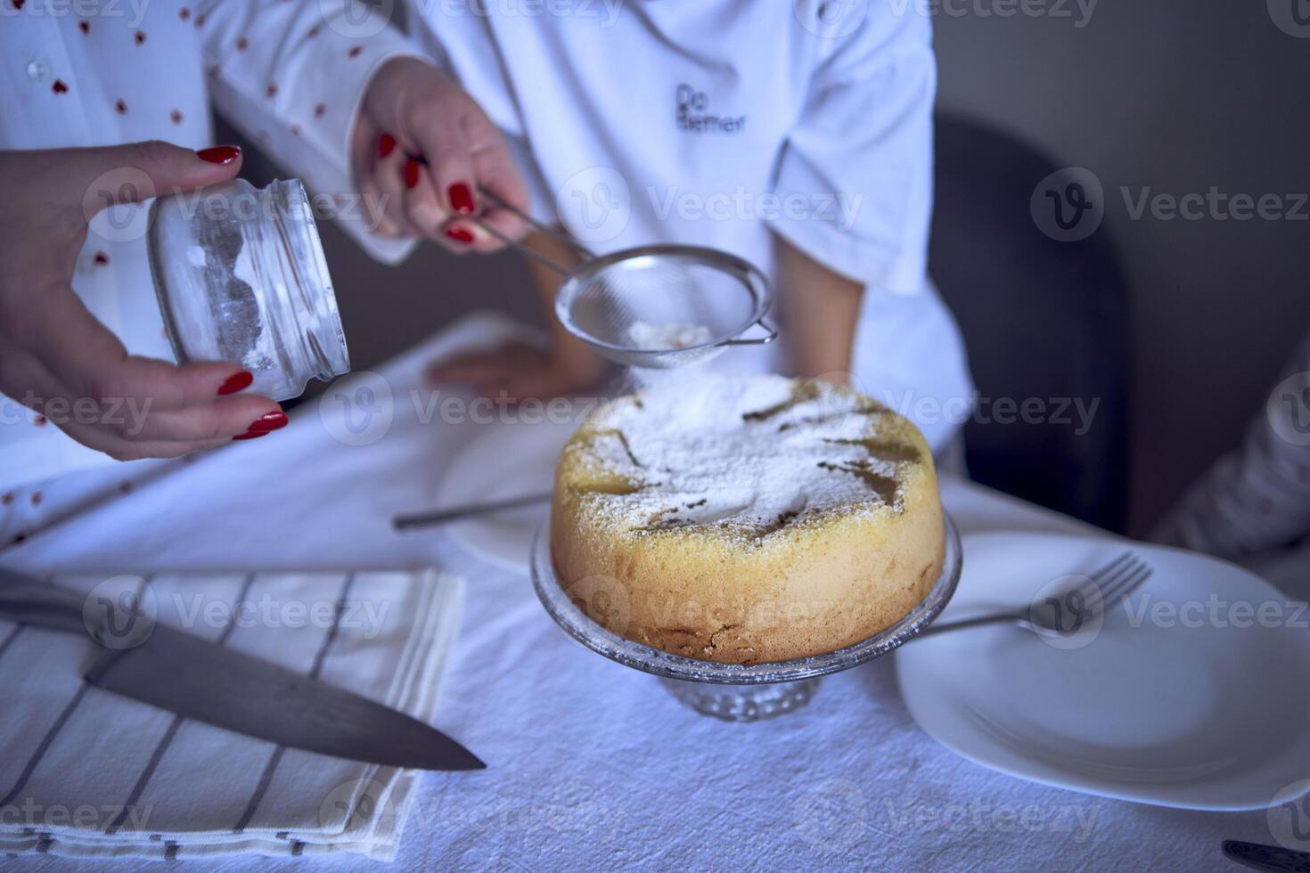 famiglia di tre, madre, adolescenziale figlia e poco figlio, mangiare torta nel pigiama a un' tavolo con tulipani foto