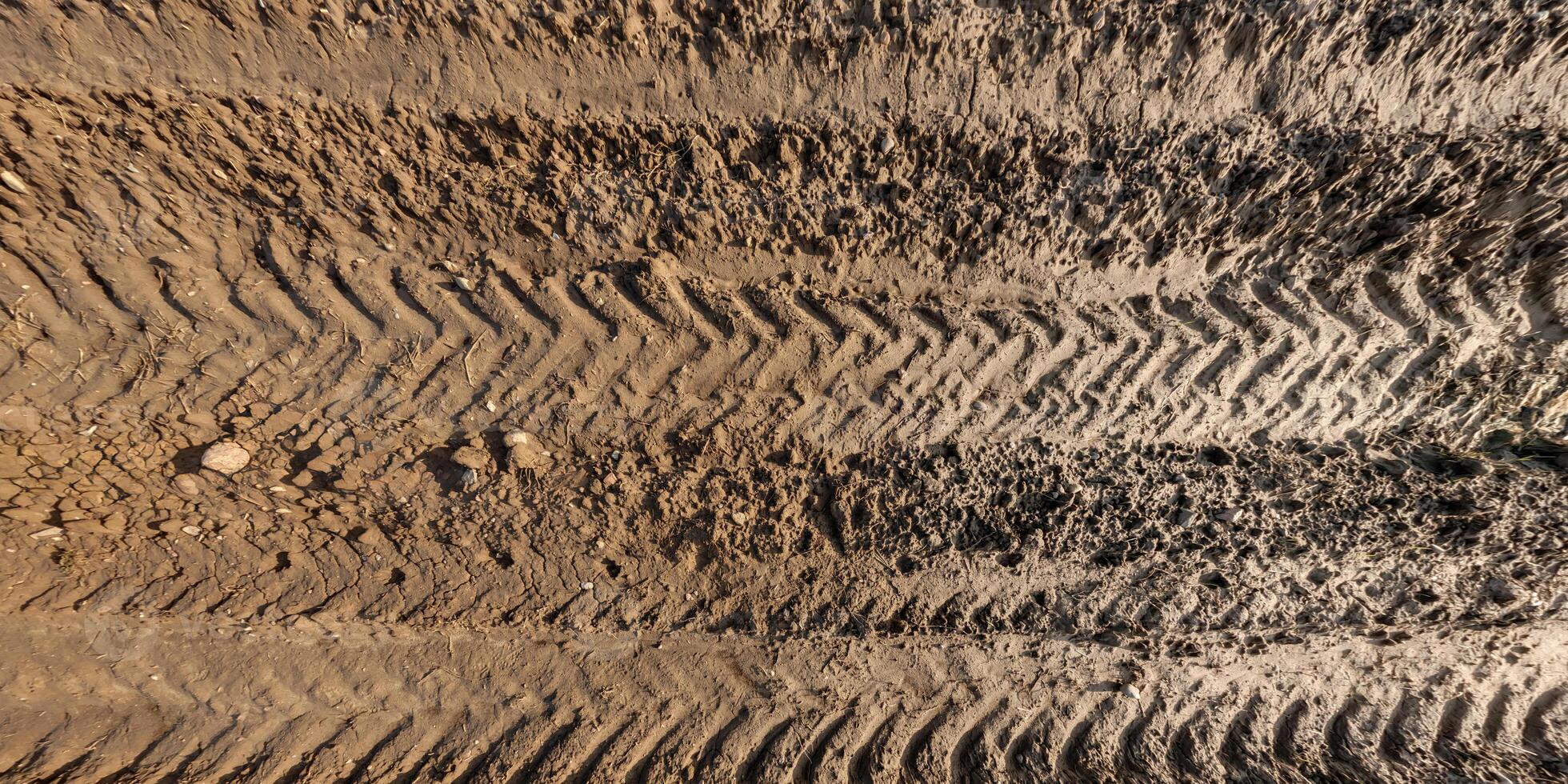 panorama di fangoso strada a partire dal sopra su superficie di bagnato ghiaia strada con trattore pneumatico brani nel campagna foto