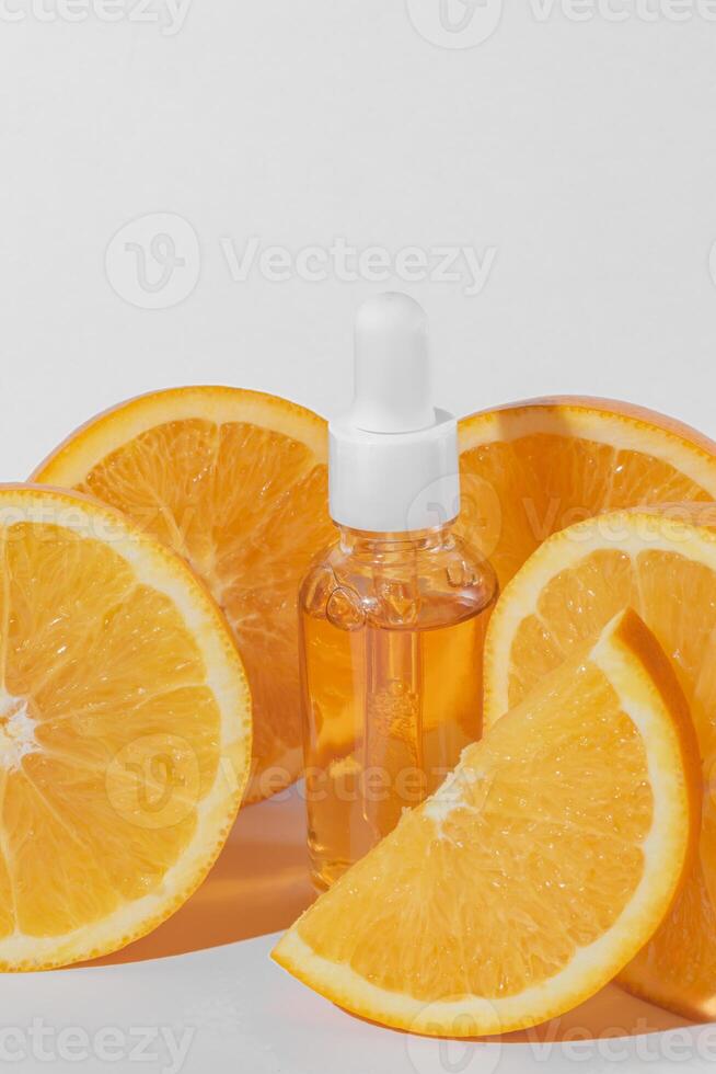 agrume essenziale olio, vitamina c siero con fresco succoso arancia frutta su bianca sfondo. biologico terme cosmetico con erbaceo ingredienti. tonificante. alto dose vitamina c sintetico per pelle foto