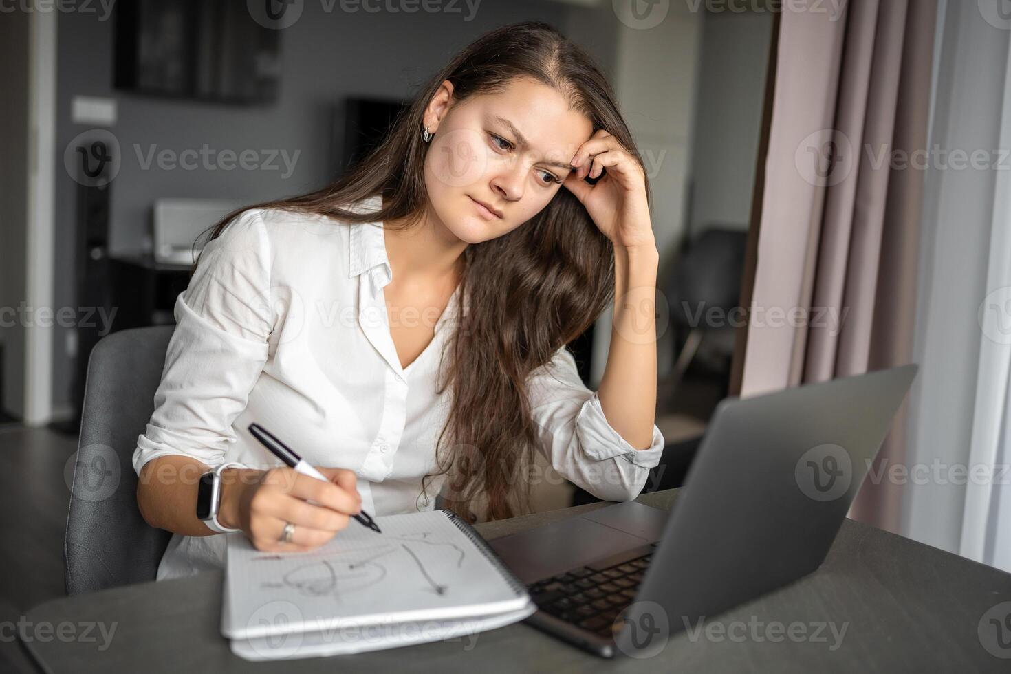 giovane stanco donna utilizzando il computer portatile nel casa posto di lavoro, scrittura Appunti, femmina alunno apprendimento e Guardando in linea seminario web o ascoltando Audio corso, e-learning formazione scolastica concetto. foto