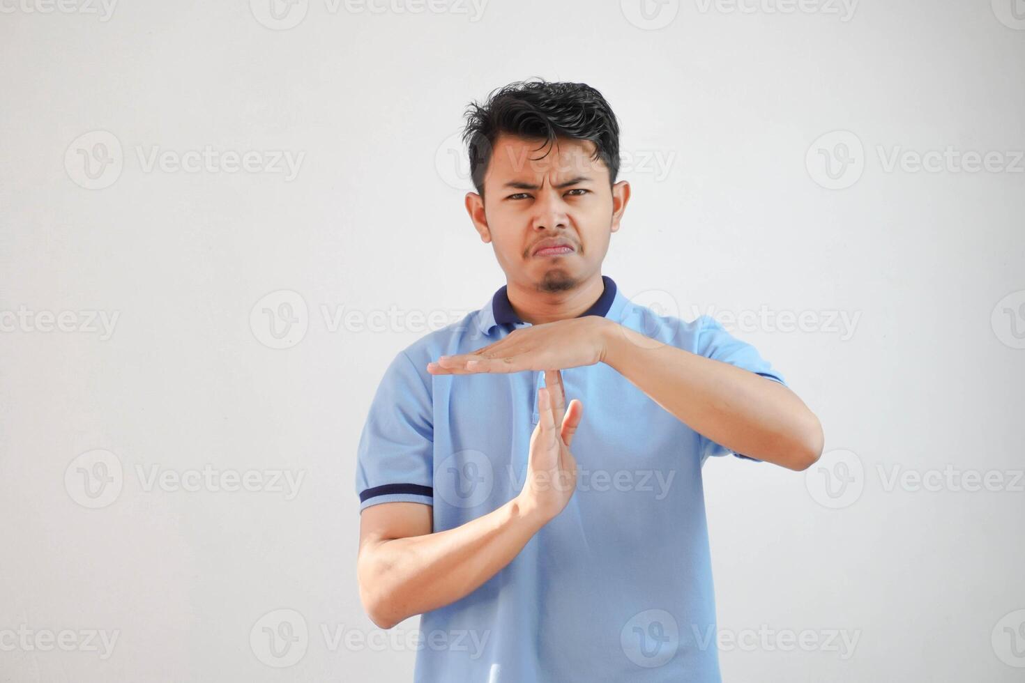 giovane asiatico uomo dando tempo su mano gesto indossare blu polo t camicia isolato su bianca sfondo foto