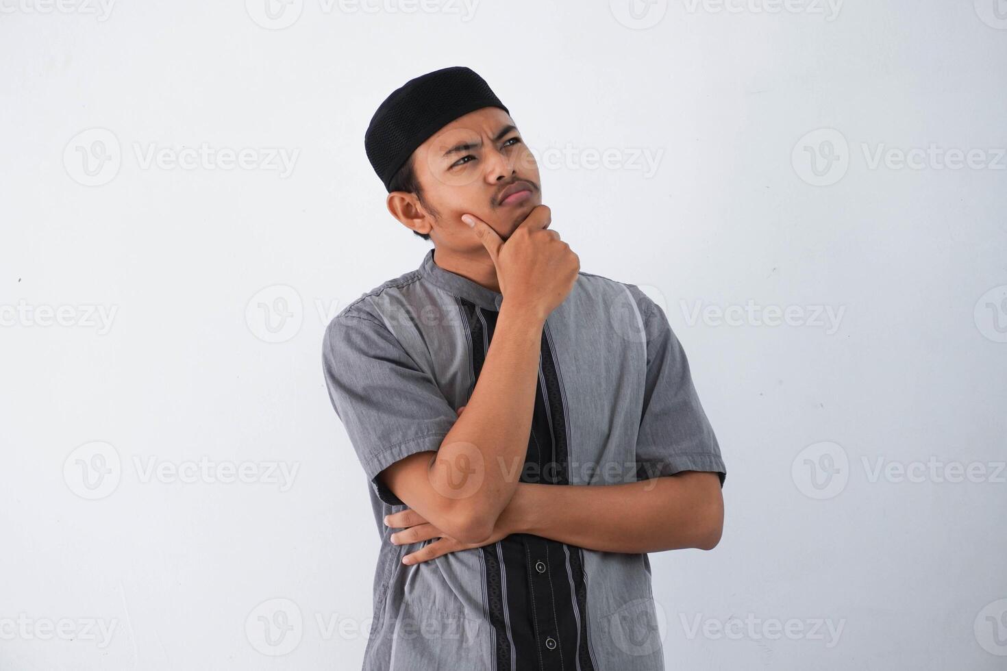 pensiero giovane asiatico musulmano uomo Tenere mento pensiero gesto, guardare per idea indossare grigio musulmano Abiti isolato su bianca sfondo foto