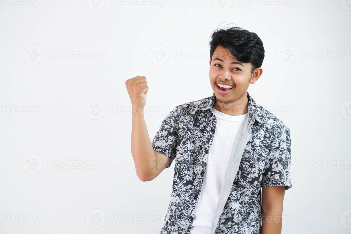 fiducioso allegro bello asiatico uomo sollevamento mani su indossare nero camicia si sente felicità mostrare cazzotto su successo isolato su bianca sfondo foto