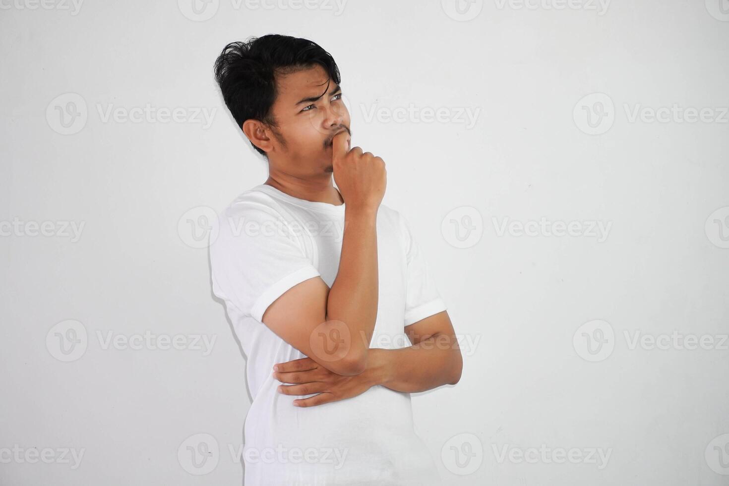 pensiero giovane asiatico uomo Tenere mento pensiero gesto, guardare per idea indossare bianca t camicia isolato su bianca sfondo foto