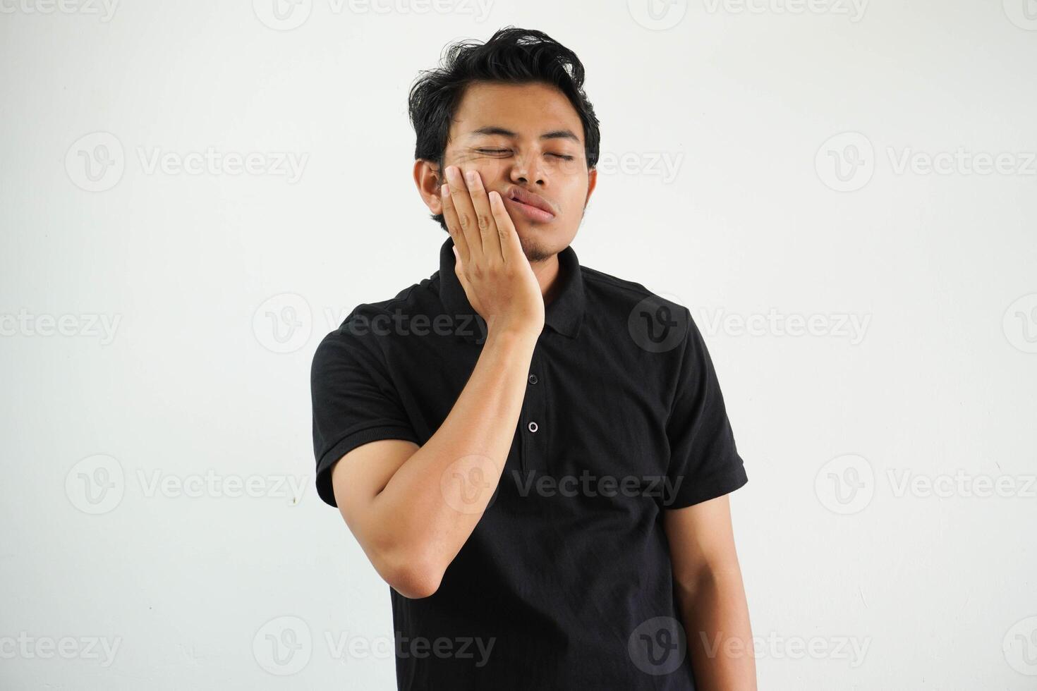 bello giovane asiatico uomo indossare nero polo t camicia toccante bocca con mano con doloroso espressione perché di mal di denti o dentale malattia su denti. dentista foto