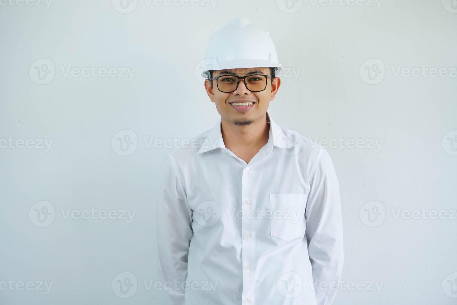 sorridente giovane asiatico uomo ingegneria mostrando eccitato espressione con guardare telecamera isolato su bianca sfondo foto