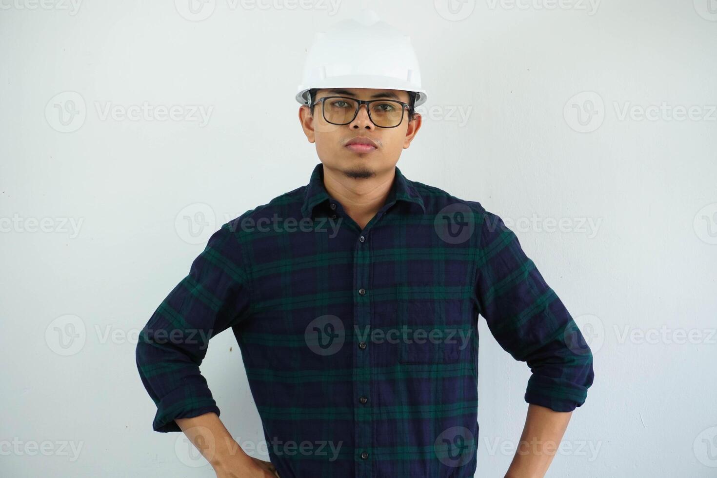 grave giovane asiatico uomo ingegneria guardare telecamera con tutti e due mano su il suo vita isolato su bianca sfondo foto
