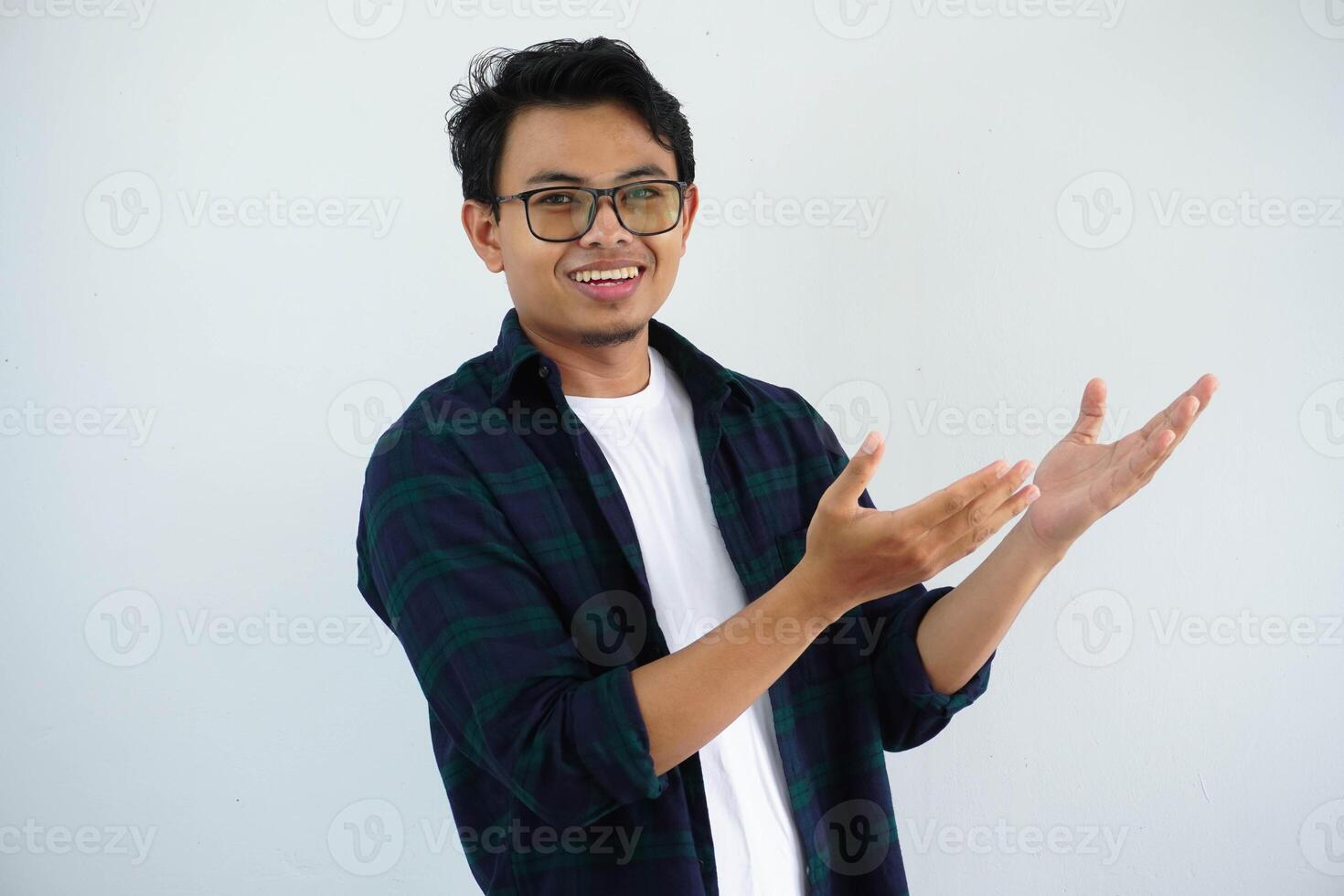 sorridente giovane asiatico uomo mostrando qualcosa sinistra lato isolato su bianca sfondo foto