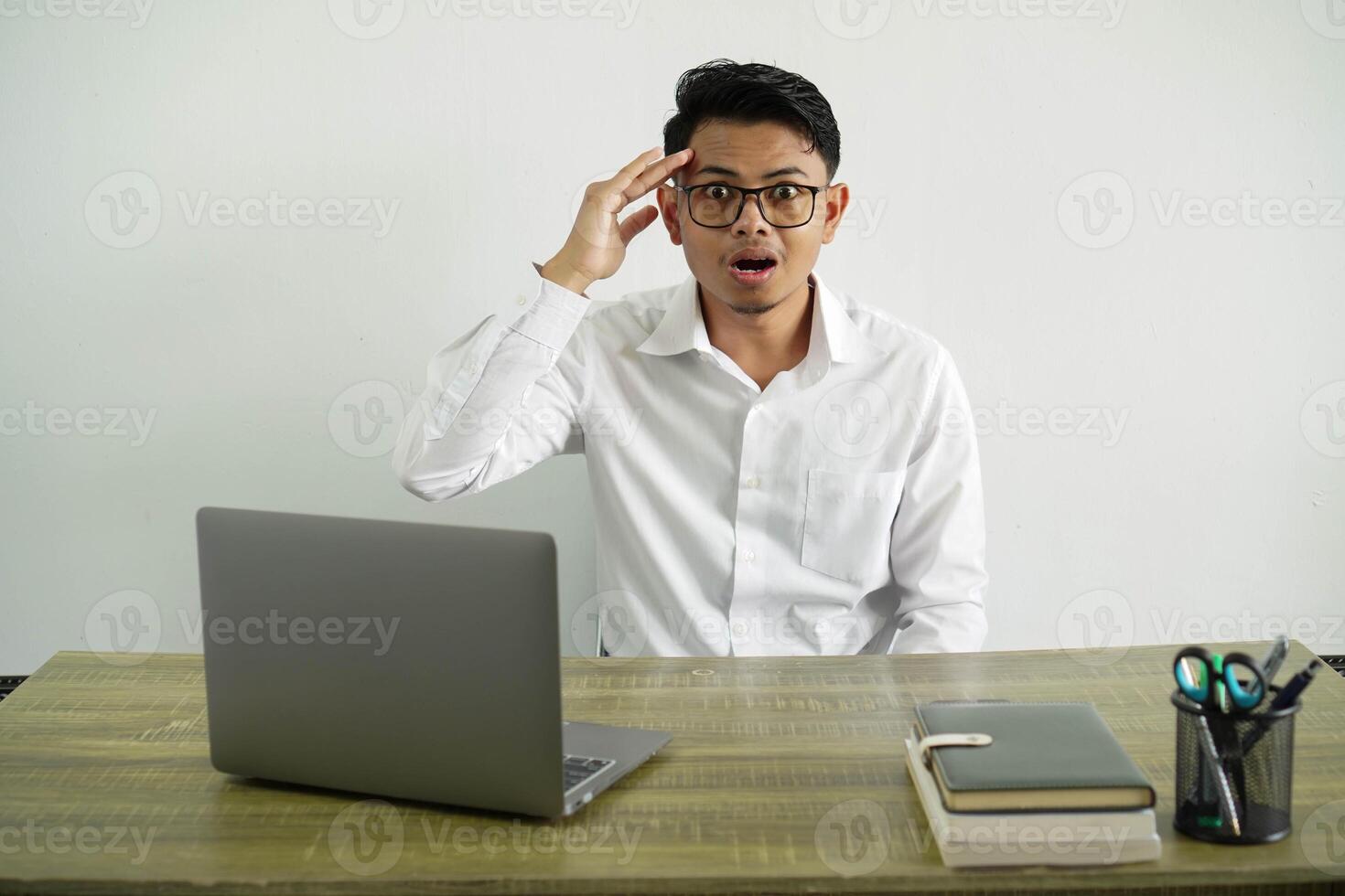 giovane asiatico uomo d'affari nel un' posto di lavoro ha appena realizzato qualcosa e ha intenzione il soluzione, indossare bianca camicia con bicchieri isolato foto