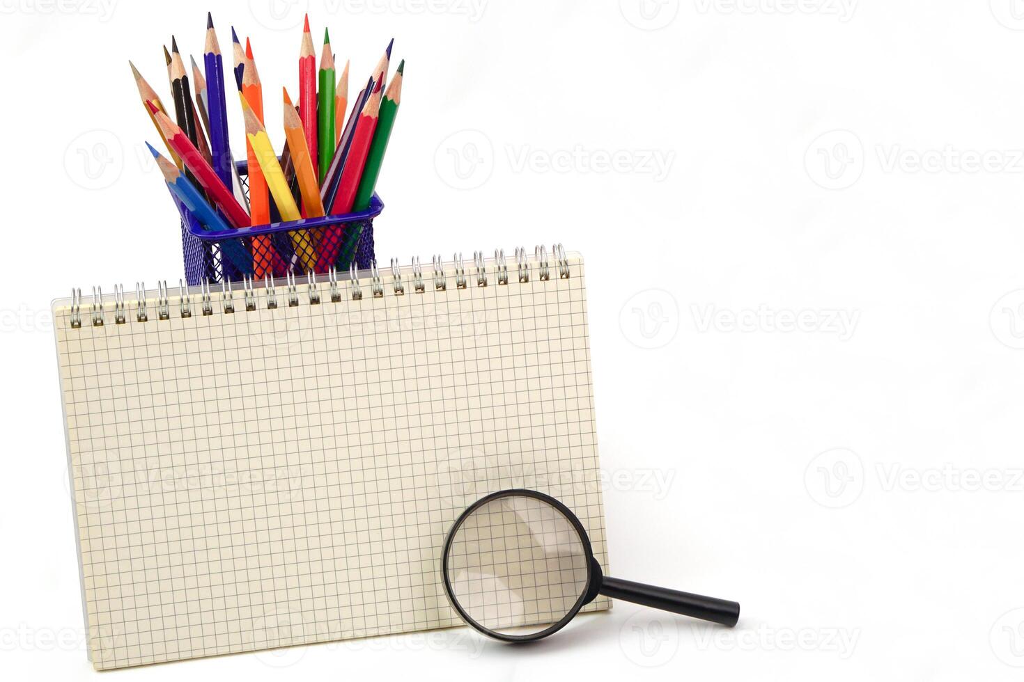 pastello o colorato matite nel scatola, grafico libro e ingrandimento bicchiere è posto nel davanti su bianca sfondo. apprendimento, studia e presentazione concetto. foto
