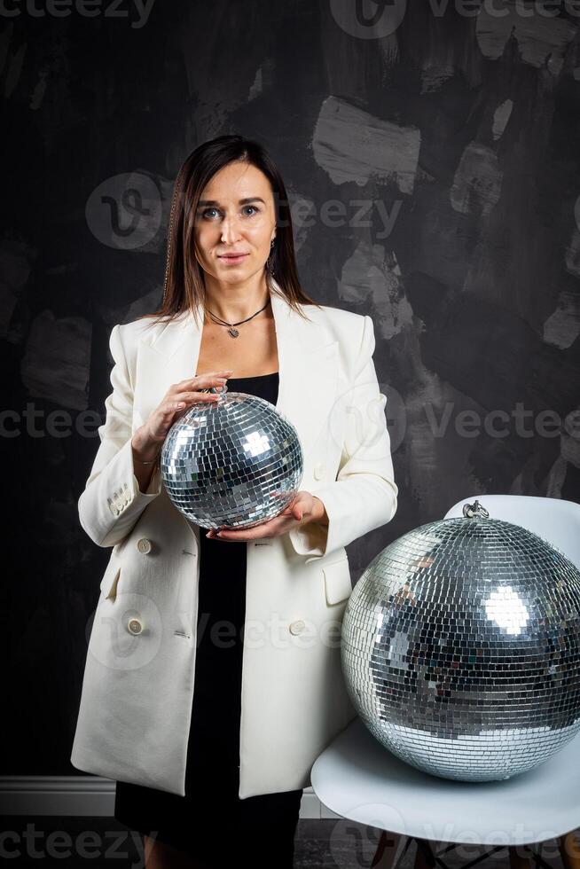 ritratto di un' donna Tenere un' argento discoteca sfera. prese nel un' foto studio.