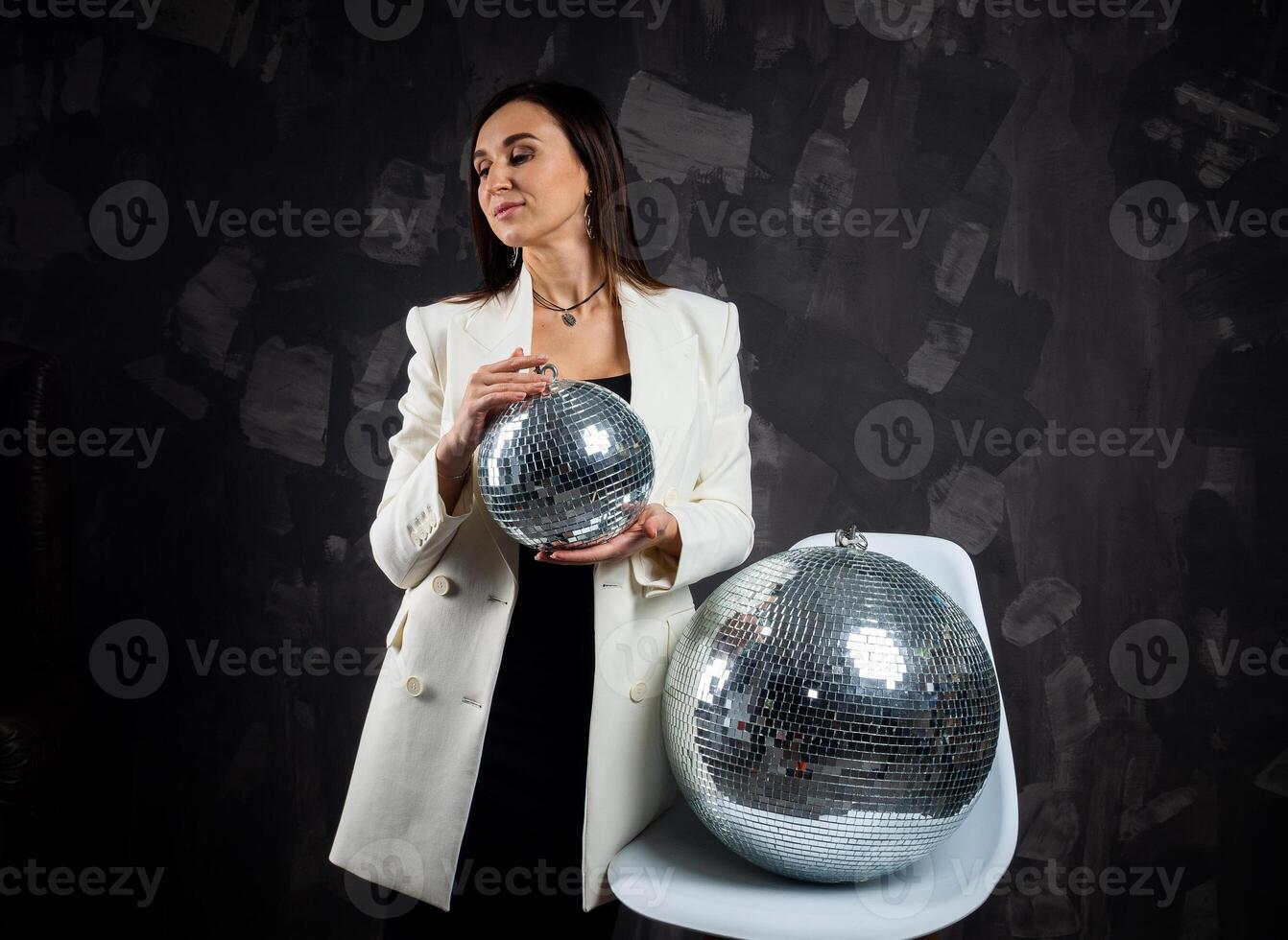 ritratto di un' donna Tenere un' argento discoteca sfera. prese nel un' foto studio.