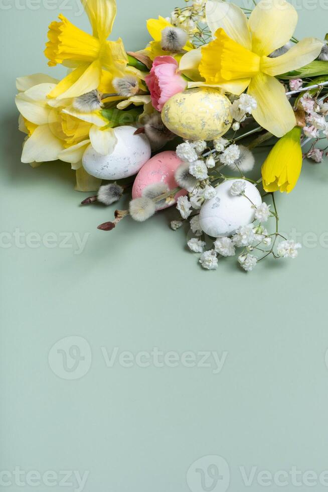 giallo narcisi, Pasqua uova e salice su verde sfondo con copia spazio foto