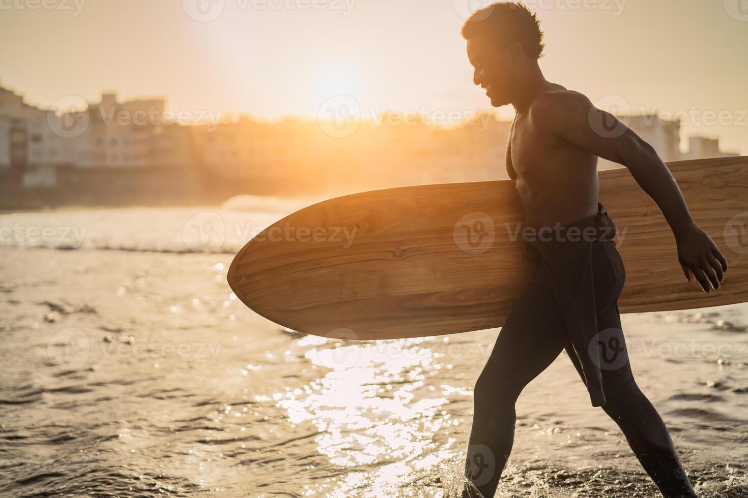 maschio afro surfer avendo divertimento fare surf durante tramonto tempo - africano uomo godendo Surf giorno - estremo sport stile di vita persone concetto foto