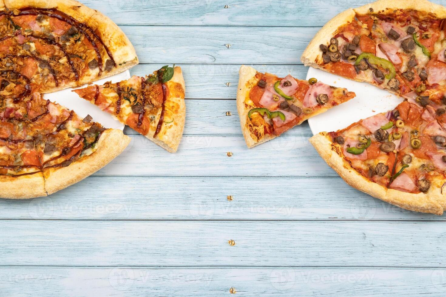 Due diverso delizioso grande pizze su un' blu di legno sfondo foto