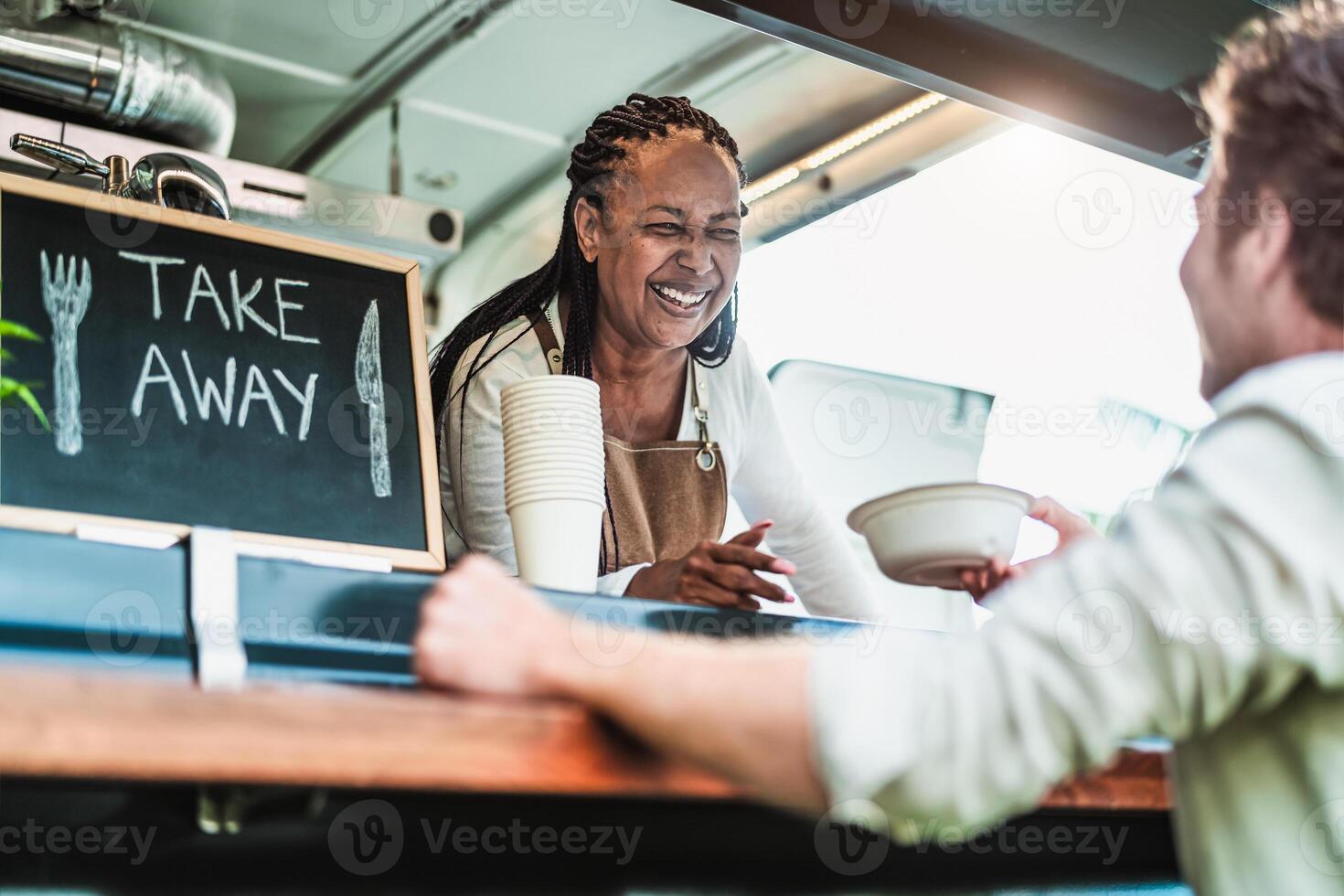 femmina cibo camion proprietario servendo pasto per maschio cliente - moderno attività commerciale e prendere lontano concetto foto