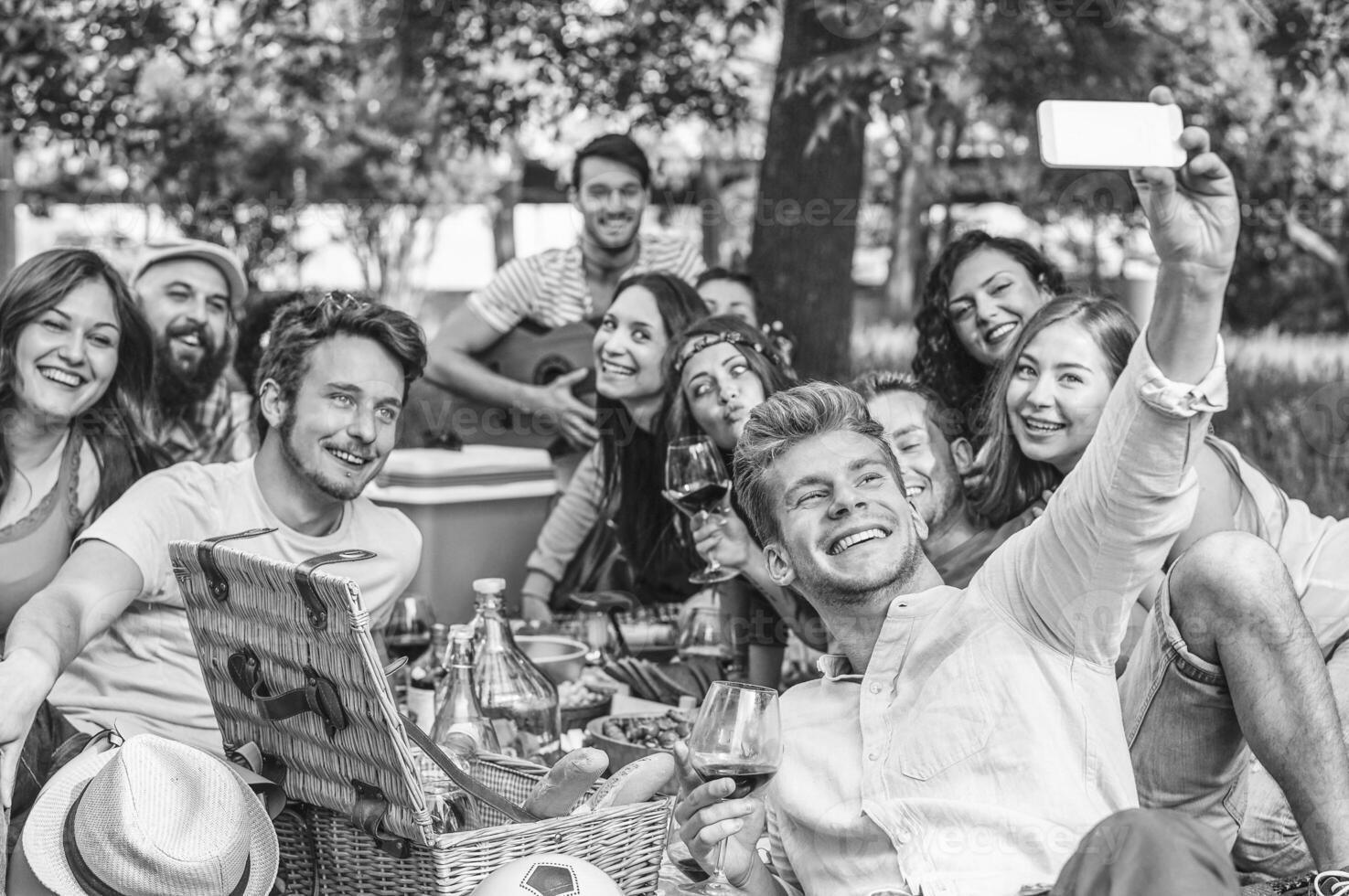 gruppo di amici fabbricazione un' picnic barbecue e assunzione autoscatto con mobile smartphone nel parco all'aperto - contento persone avendo divertimento insieme mangiare e potabile vino - amicizia, gioventù stile di vita concetto foto