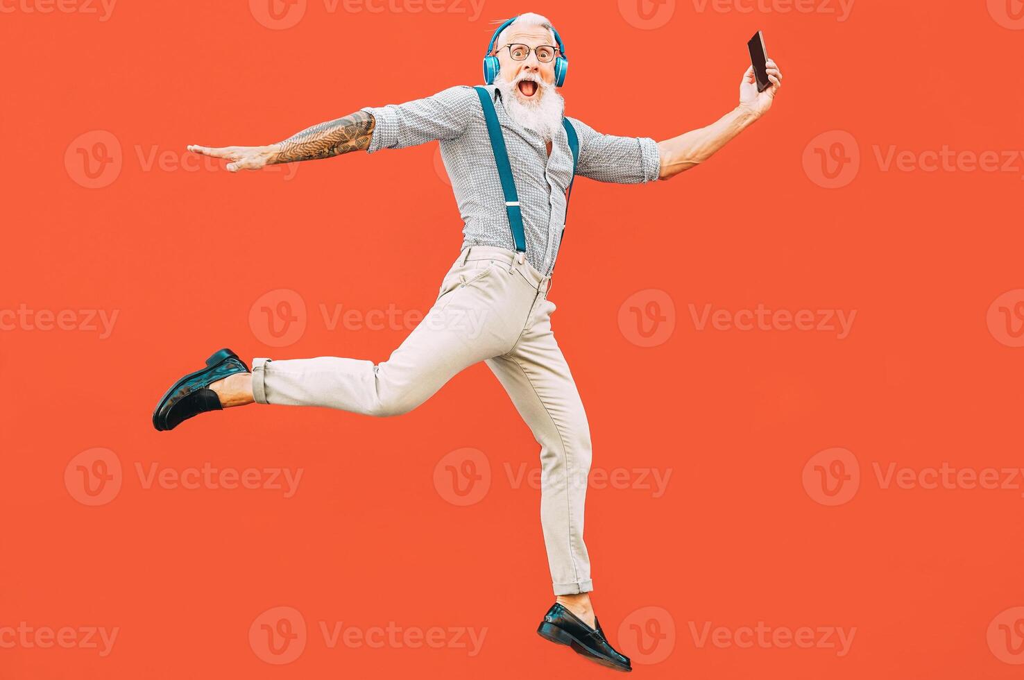 anziano pazzo uomo salto mentre ascoltando musica all'aperto - fricchettone maschio avendo divertimento danza e festeggiare vita al di fuori - felicità, tecnologia e anziano stile di vita persone concetto foto