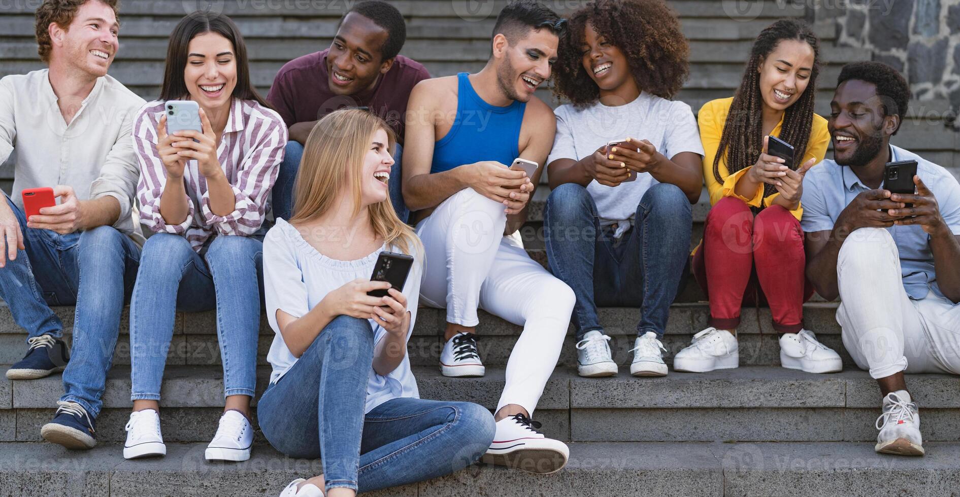 giovane multirazziale gruppo di amici utilizzando mobile smartphone seduta su le scale su di Università - gioventù del Millennio stile di vita concetto foto