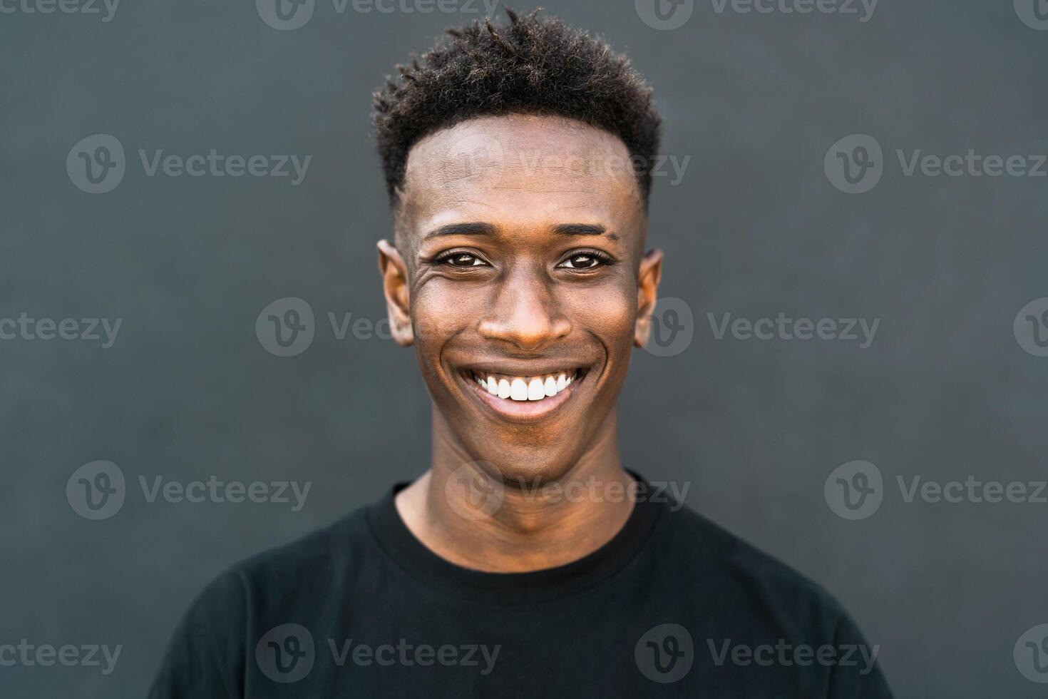 contento giovane africano adolescente sorridente nel davanti di telecamera foto