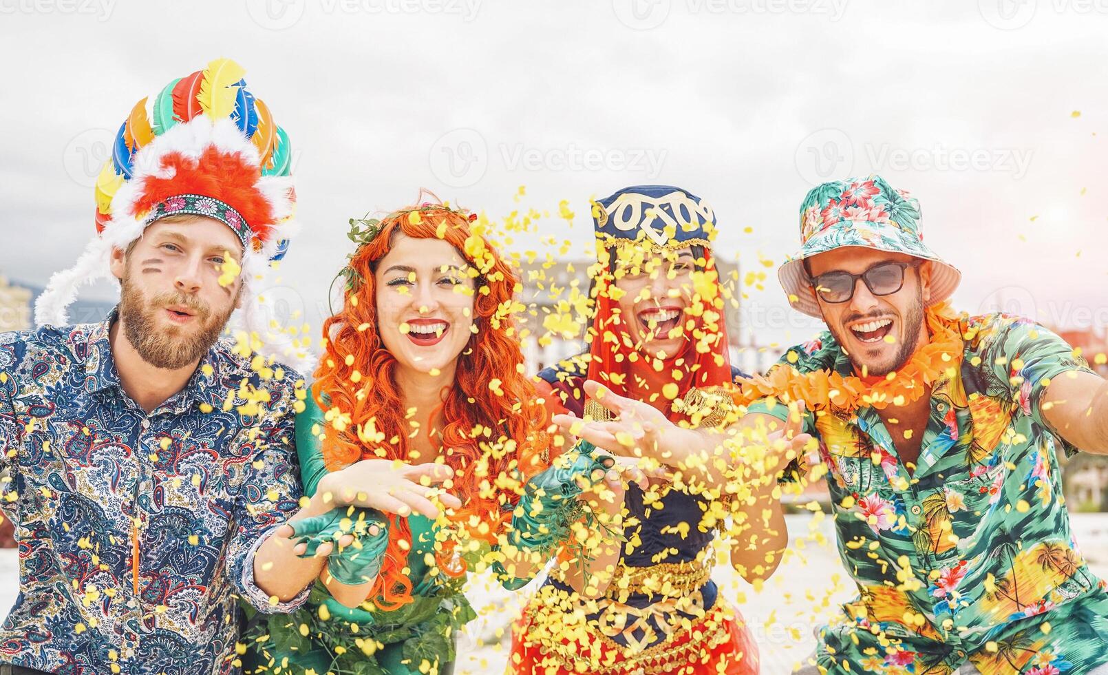 contento amici festeggiare a carnevale brasiliano festa - giovane persone indossare carnevale costumi avendo divertimento lancio coriandoli e ridendo insieme all'aperto - concetto di gioventù stile di vita vacanze foto