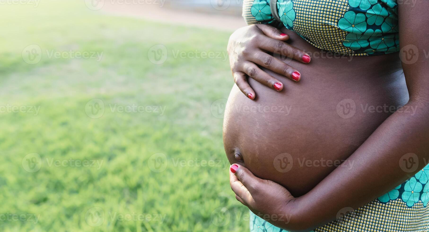 vicino su incinta pancia di giovane africano donna nel parco - maternità stile di vita concetto foto