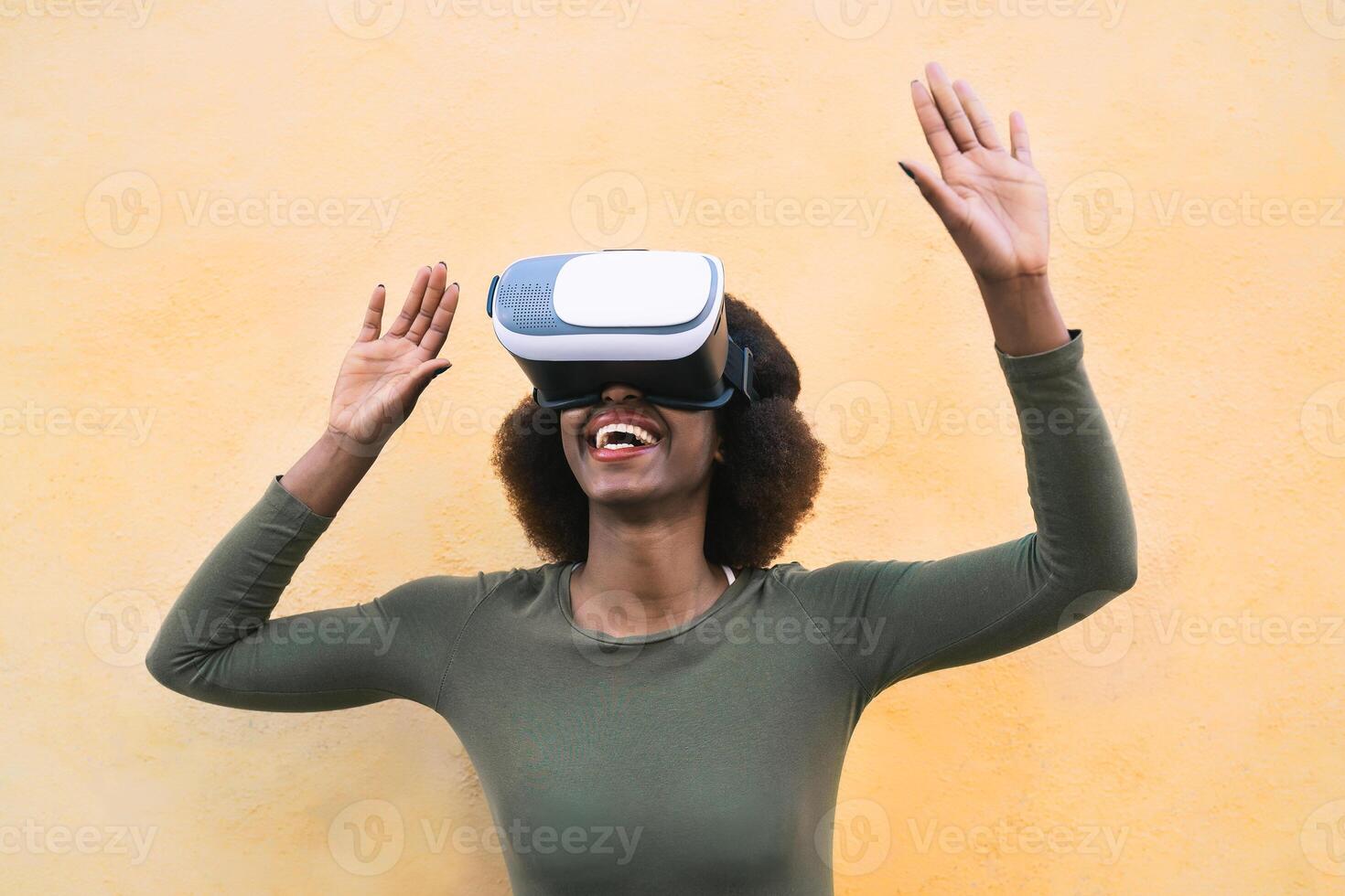 contento afro donna utilizzando virtuale la realtà cuffia all'aperto - di moda ragazza avendo divertimento con innovato vr googles tecnologia - Tech stile di vita divertimento e 3d gioco Esperienza concetto - giallo sfondo foto