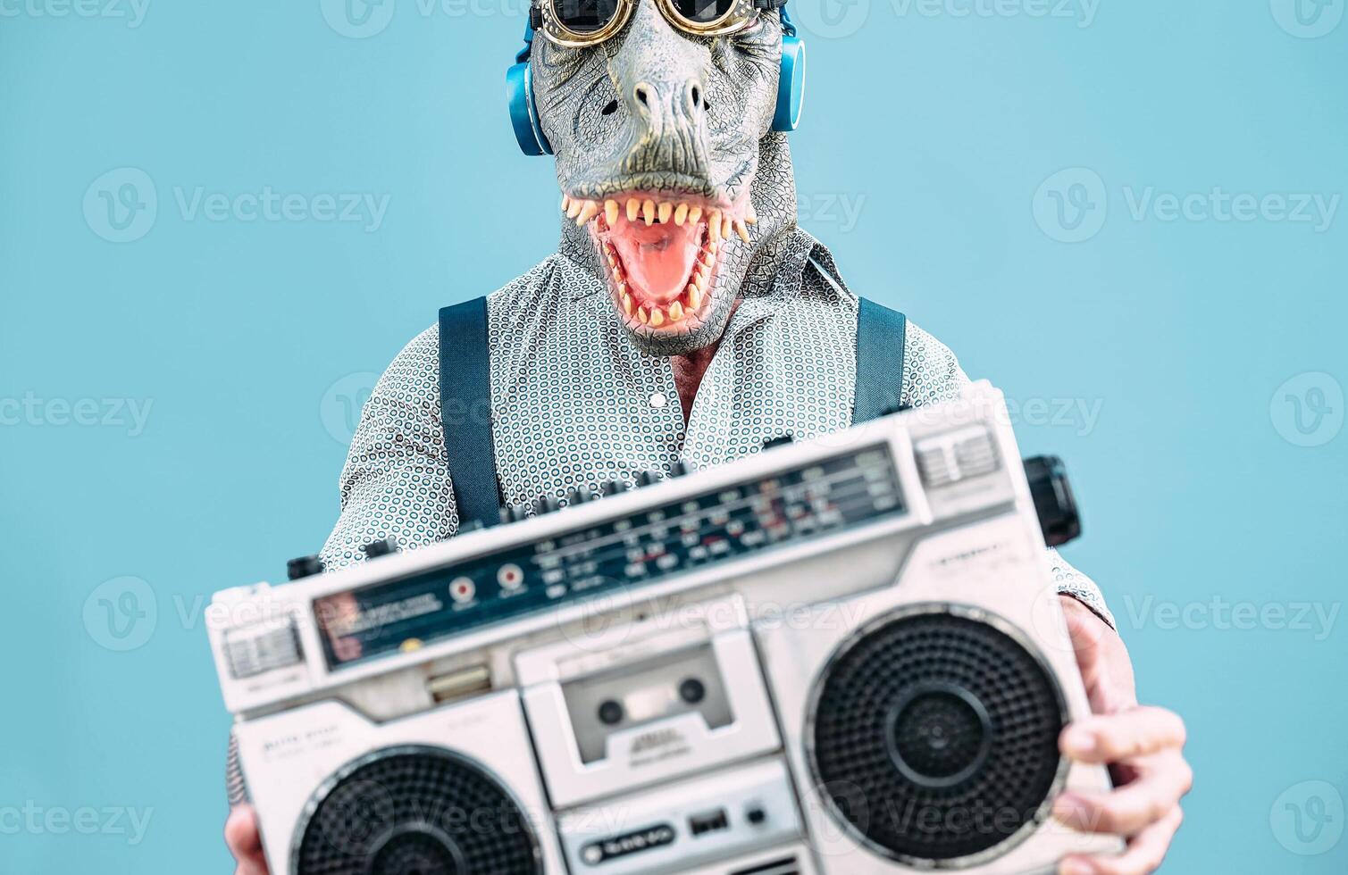 pazzo anziano uomo indossare t-rex maschera e ascoltando per musica Tenere Vintage ▾ Boombox stereo all'aperto - moda masquerade maschio avendo divertimento danza e festeggiare al di fuori - assurdo e divertente persone concetto foto