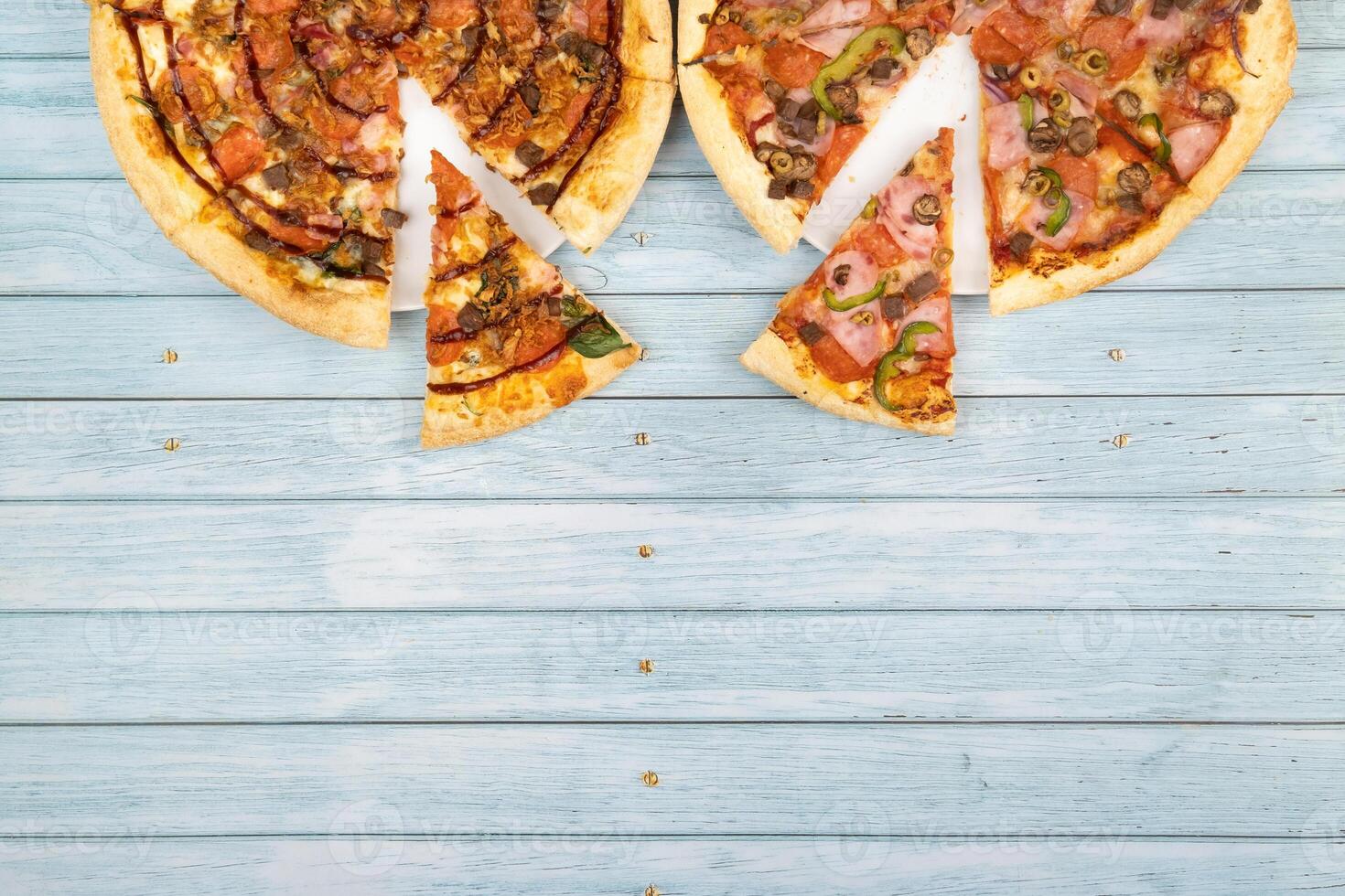 Due diverso delizioso grande pizze su un' blu di legno sfondo foto