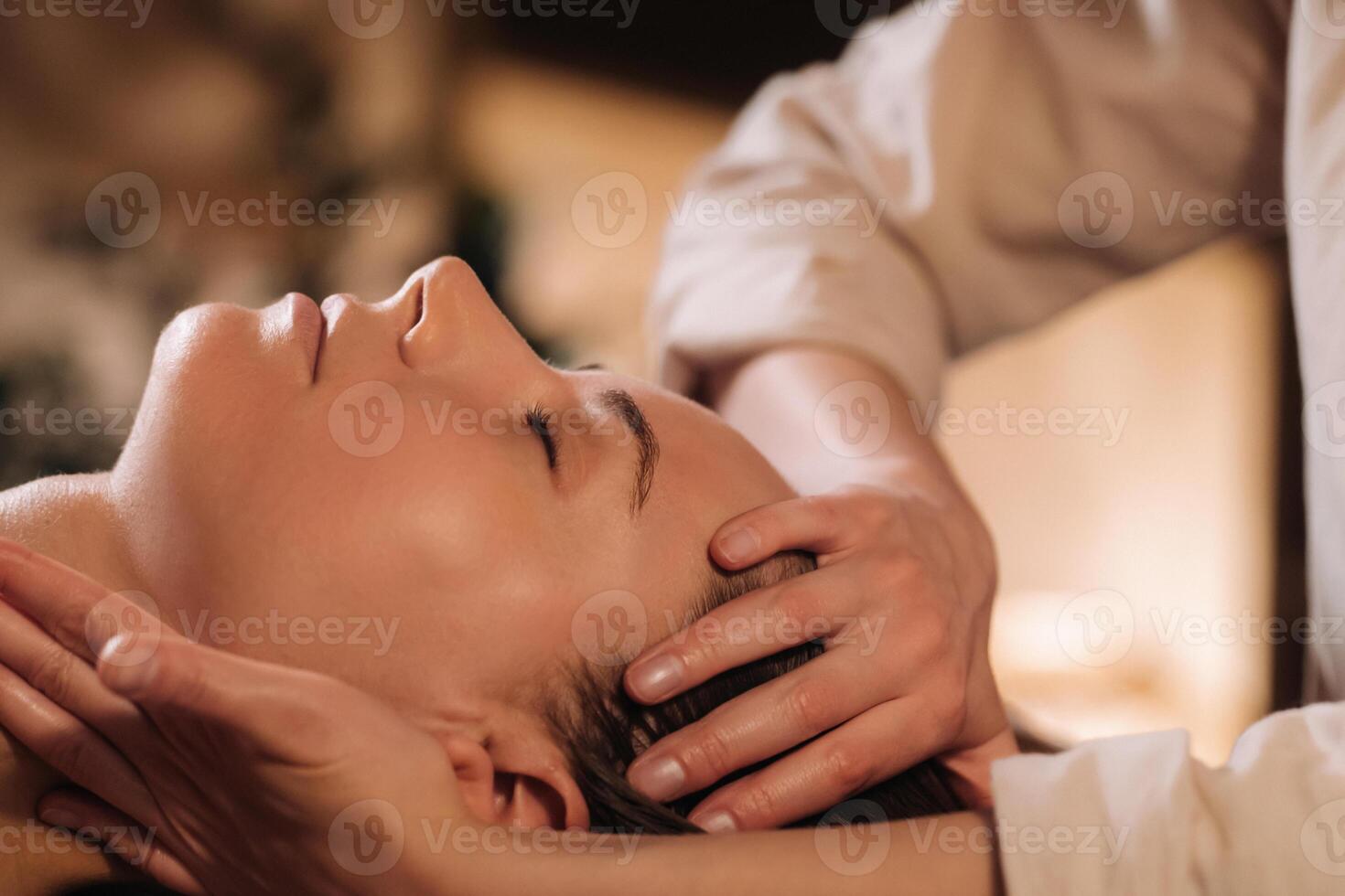 un' cosmetologo ragazza fa un' facciale e collo massaggio per un' ragazza nel il ufficio per pelle elasticità foto