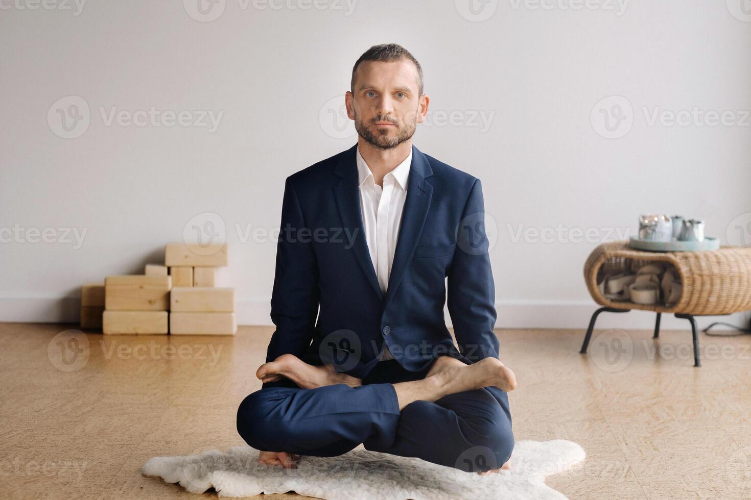 un' uomo nel un' rigoroso completo da uomo fa yoga mentre seduta nel un' fitness camera foto