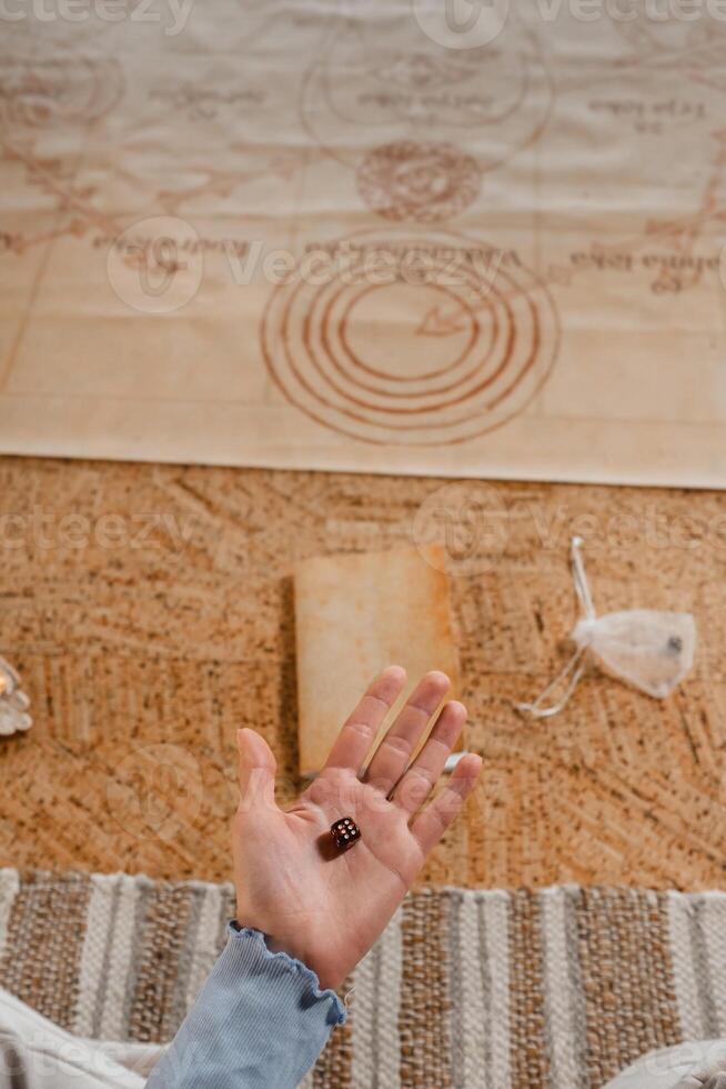 Là è un' dado nel un' di persona mano. avvicinamento di un' mano con un' dado su il sfondo di un' taccuino foto