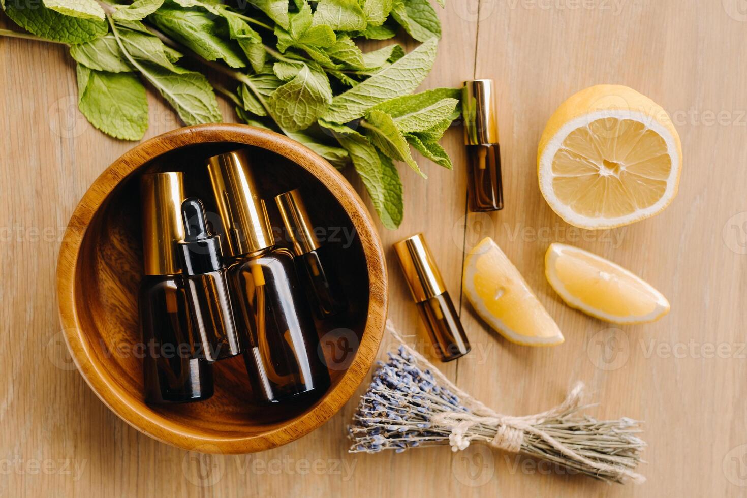 essenziale olio nel bottiglie con il aroma di Limone, menta e lavanda, dire bugie su un' di legno superficie foto