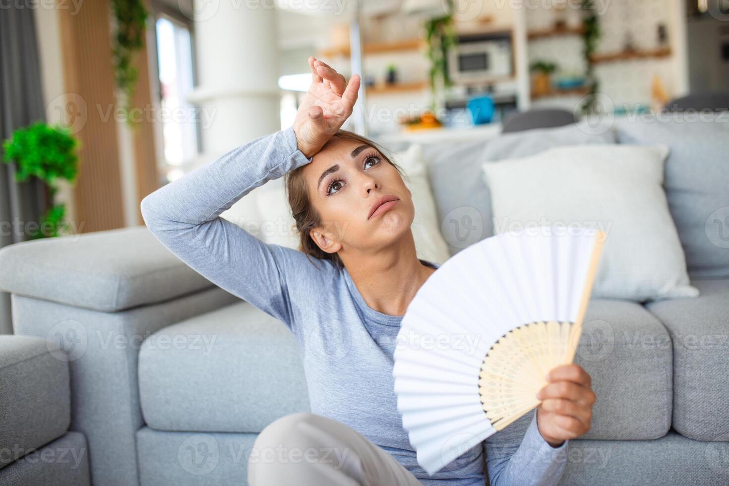 stressato infastidito donna utilizzando agitando fan soffrire a partire dal surriscaldamento, estate calore Salute ormone problema, donna sudore sentire scomodo caldo nel estate tempo metereologico problema senza aria condizionatore foto