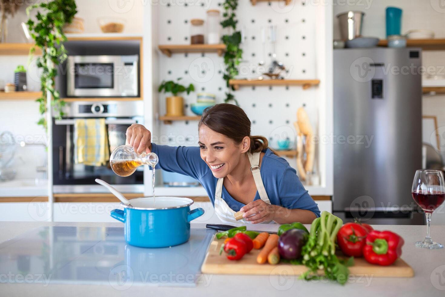 contento giovane donna cucinando degustazione cena nel un' pentola in piedi nel moderno cucina a casa. casalinga preparazione salutare cibo sorridente . domestico e nutrizione. dieta ricette concetto foto