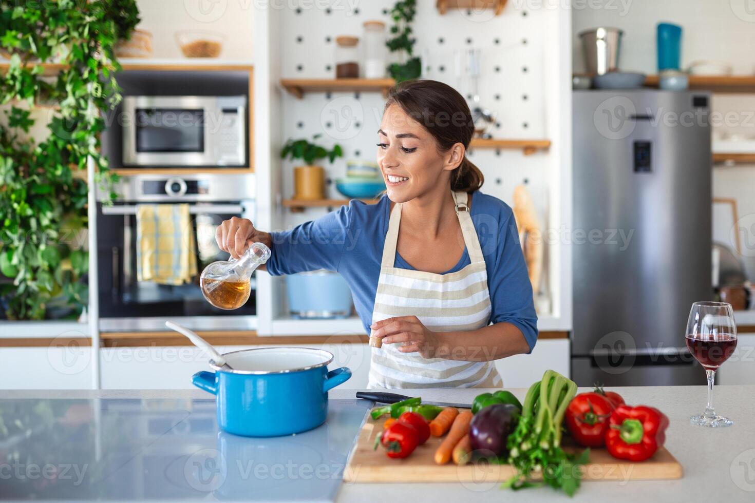 contento giovane donna cucinando degustazione cena nel un' pentola in piedi nel moderno cucina a casa. casalinga preparazione salutare cibo sorridente . domestico e nutrizione. dieta ricette concetto foto