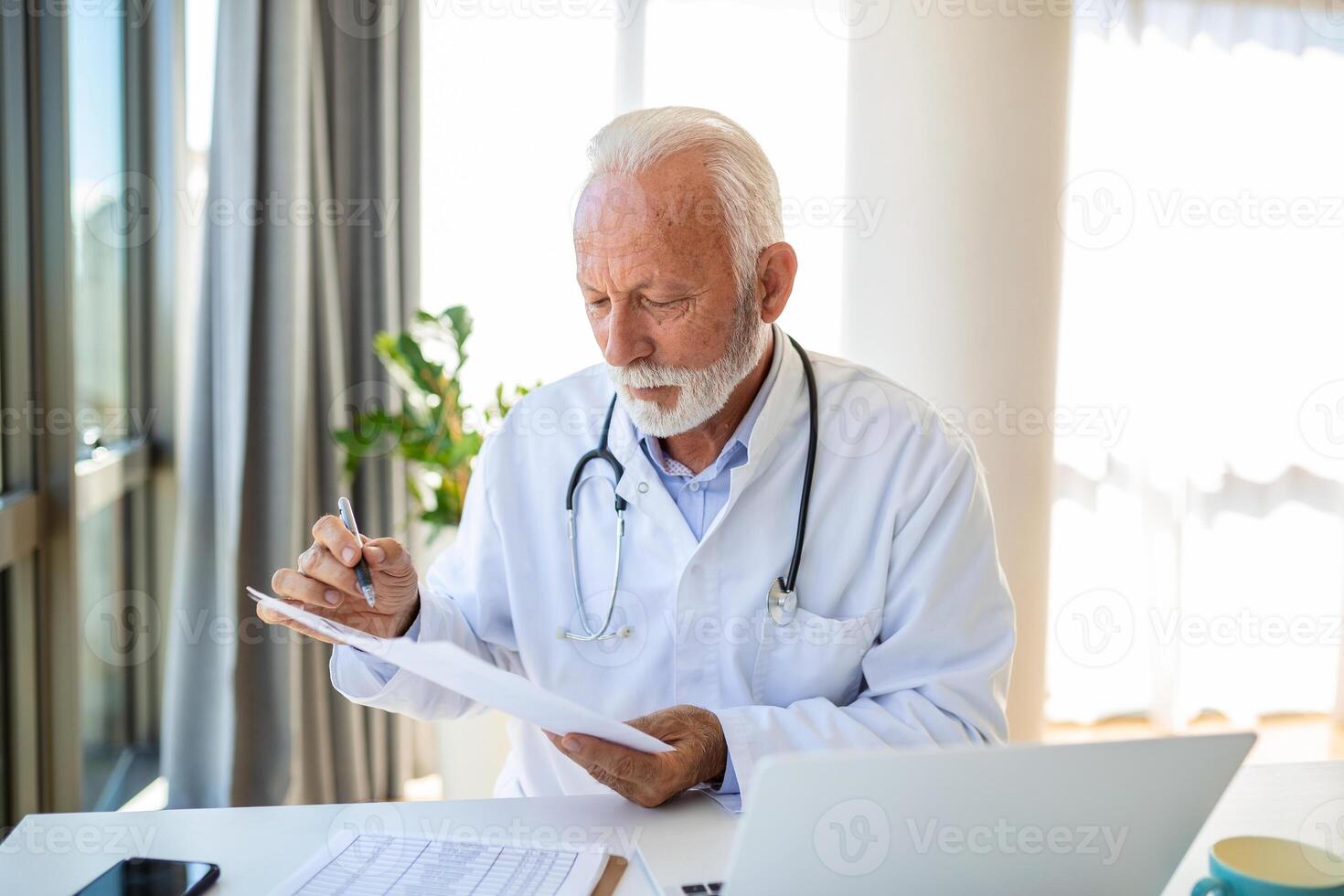 grave vecchio maturo professionale maschio medico utilizzando il computer portatile computer nel ospedale ufficio avendo medico seminario web addestramento, scrittura nel assistenza sanitaria rapporto, consulenza paziente in linea a telemedicina incontro. foto