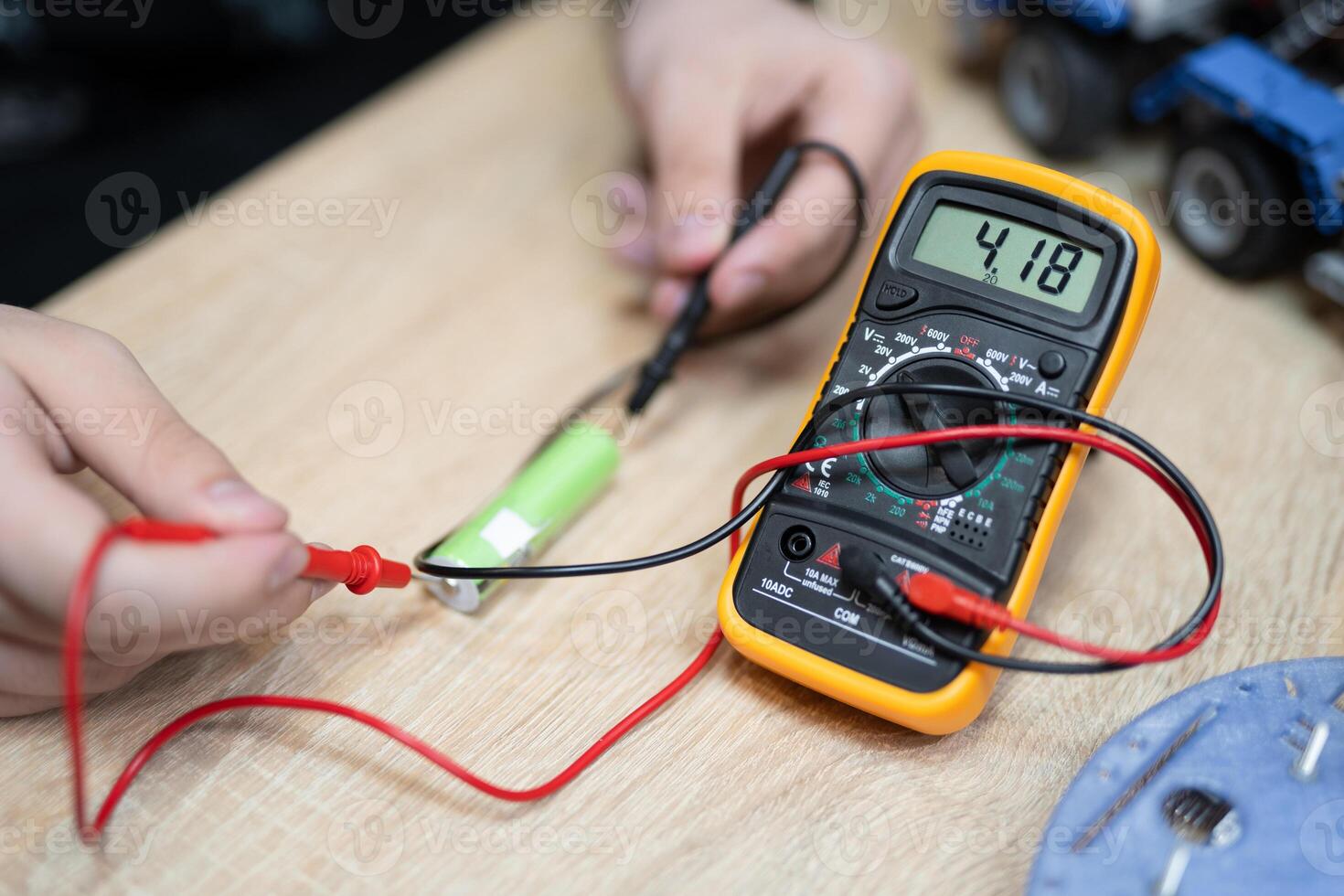 il ingegnere le misure il voltaggio su il batteria con un' multimetro foto