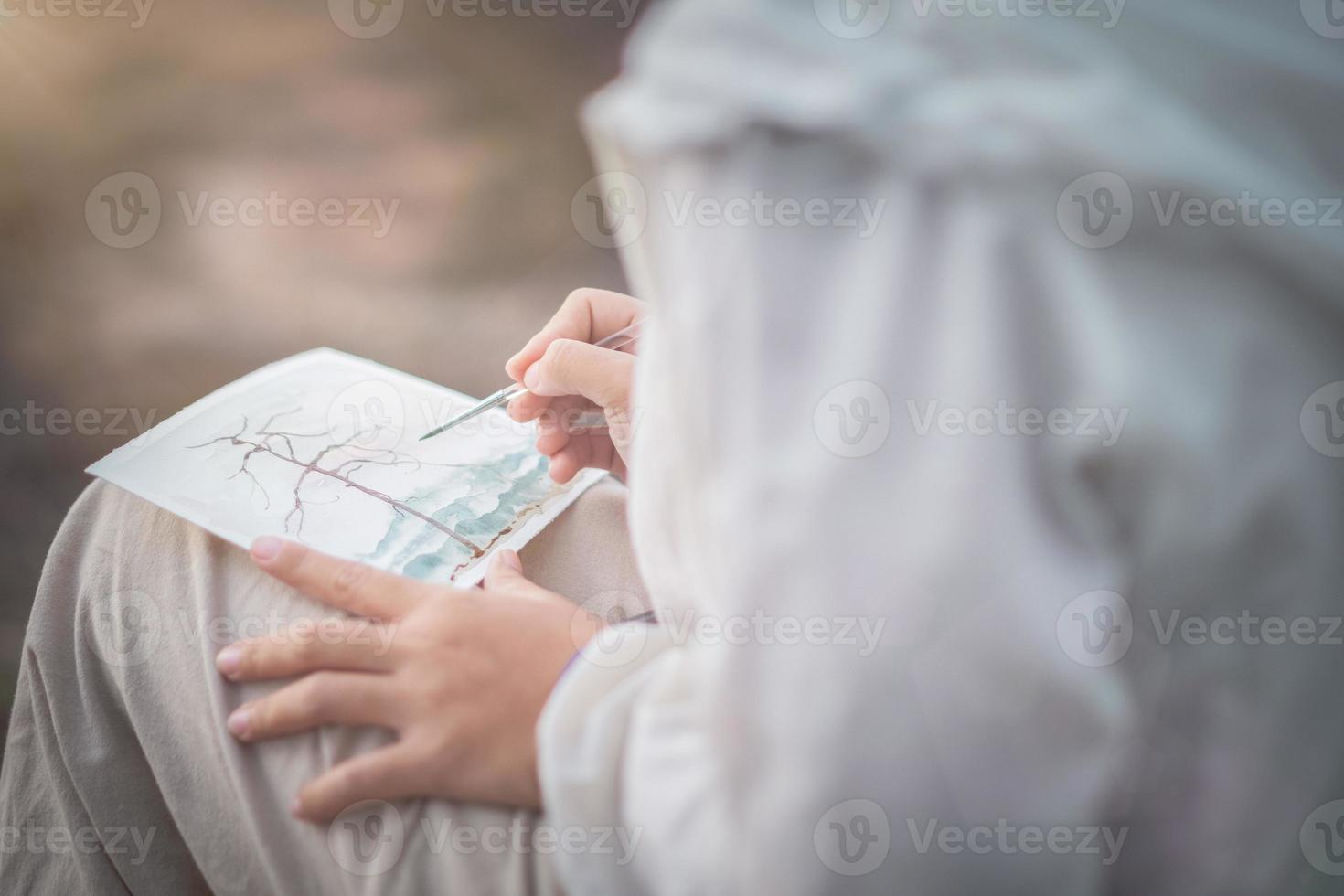 ragazza seduta a dipingere in una giornata di sole foto