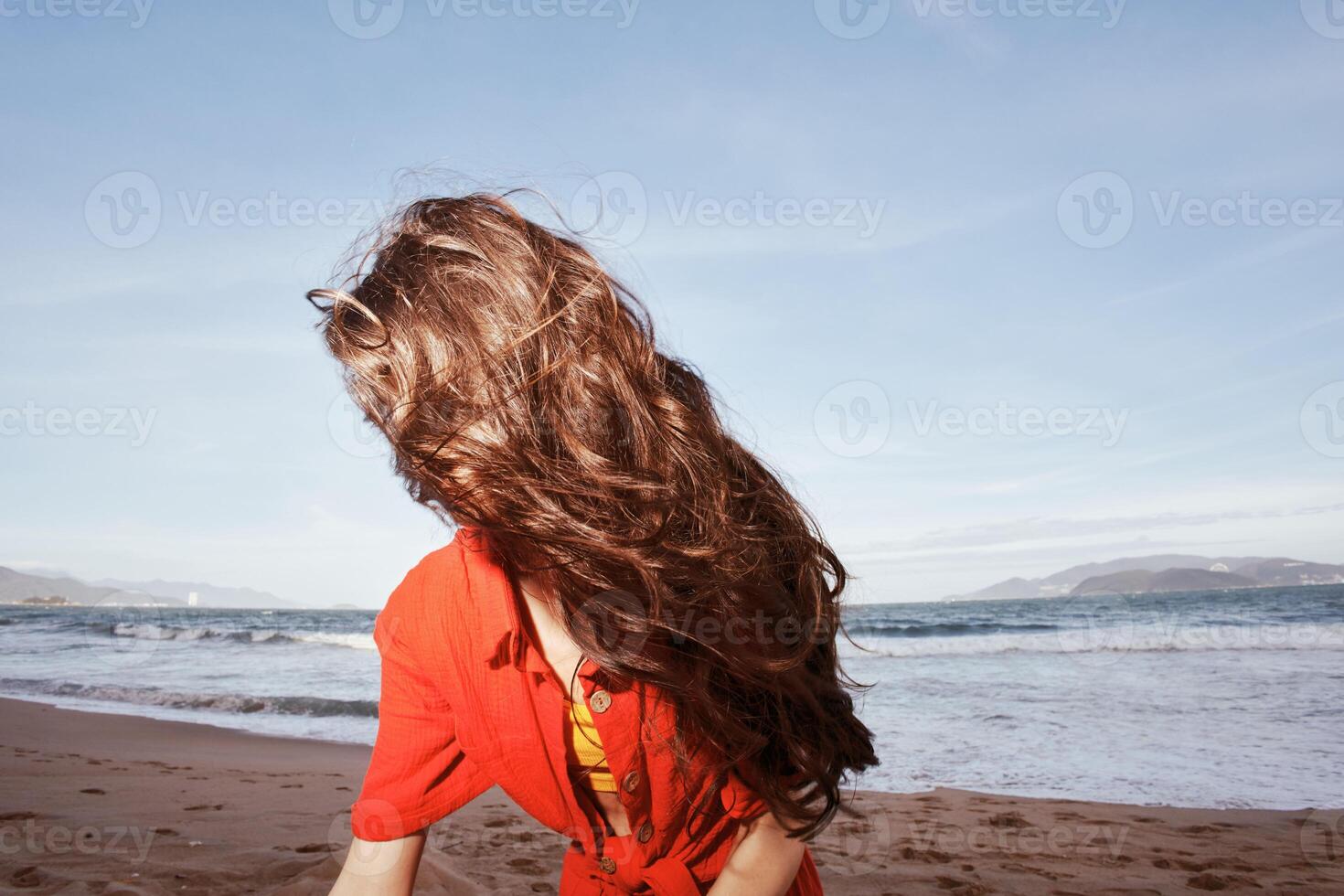 sorridente donna godendo la libertà e gioia su il spiaggia, circondato di della natura bellezza foto