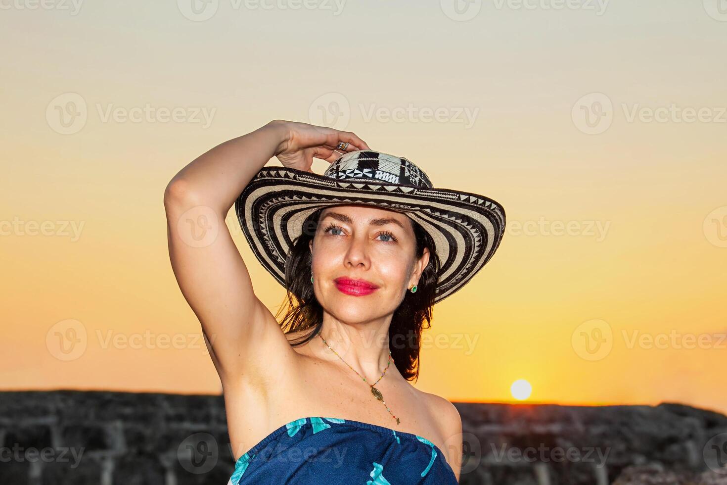 bellissimo donna indossare il tradizionale colombiano cappello chiamato sombrero vueltiao a il storico muri di cartagena de indie foto