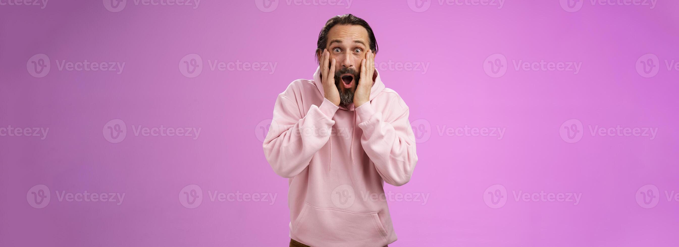 divertito molto contento adulto barbuto papà ricevere incredibile degno di nota mazzo i soldi urlando con gioia toccare guance allargare occhi stupito non può credere Come fortunato, in piedi viola sfondo entusiasta foto