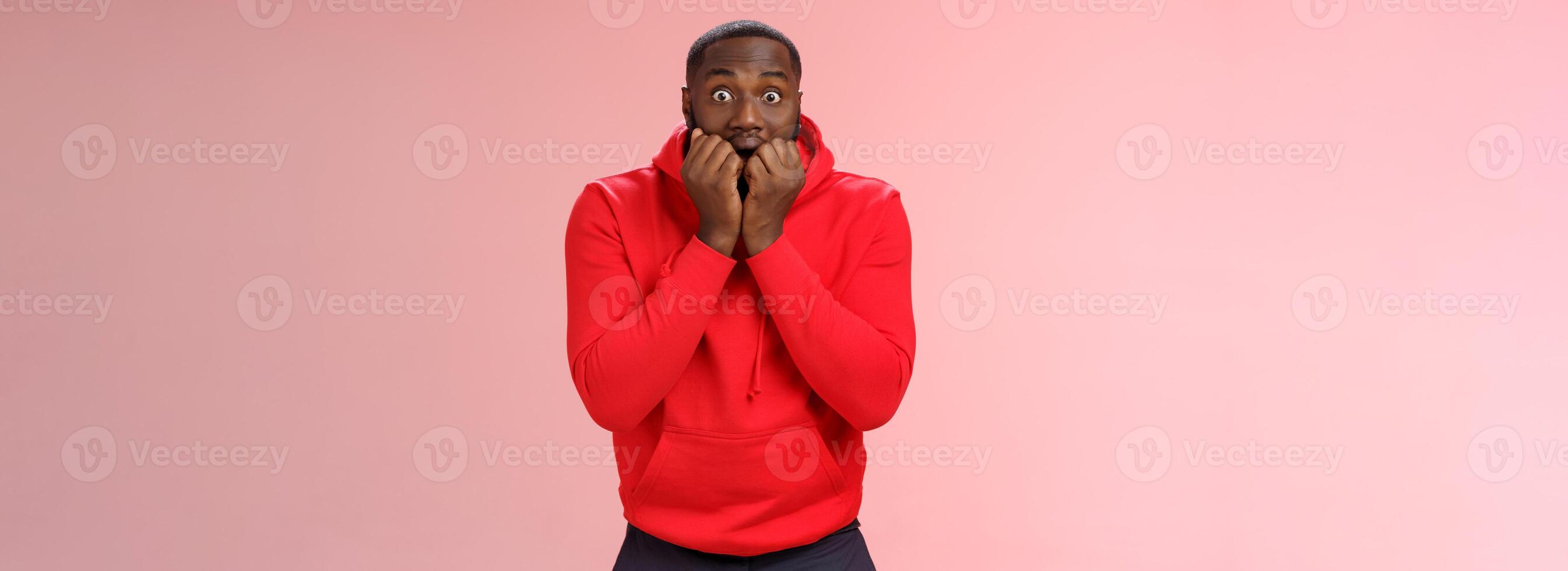 eccitato sopraffatto giovane africano americano barbuto uomo pungente dita allargare occhi impressionato sta morendo anticipando vedere fama cantante vivere anticipando emozionante momento, in piedi rosa sfondo nervoso foto